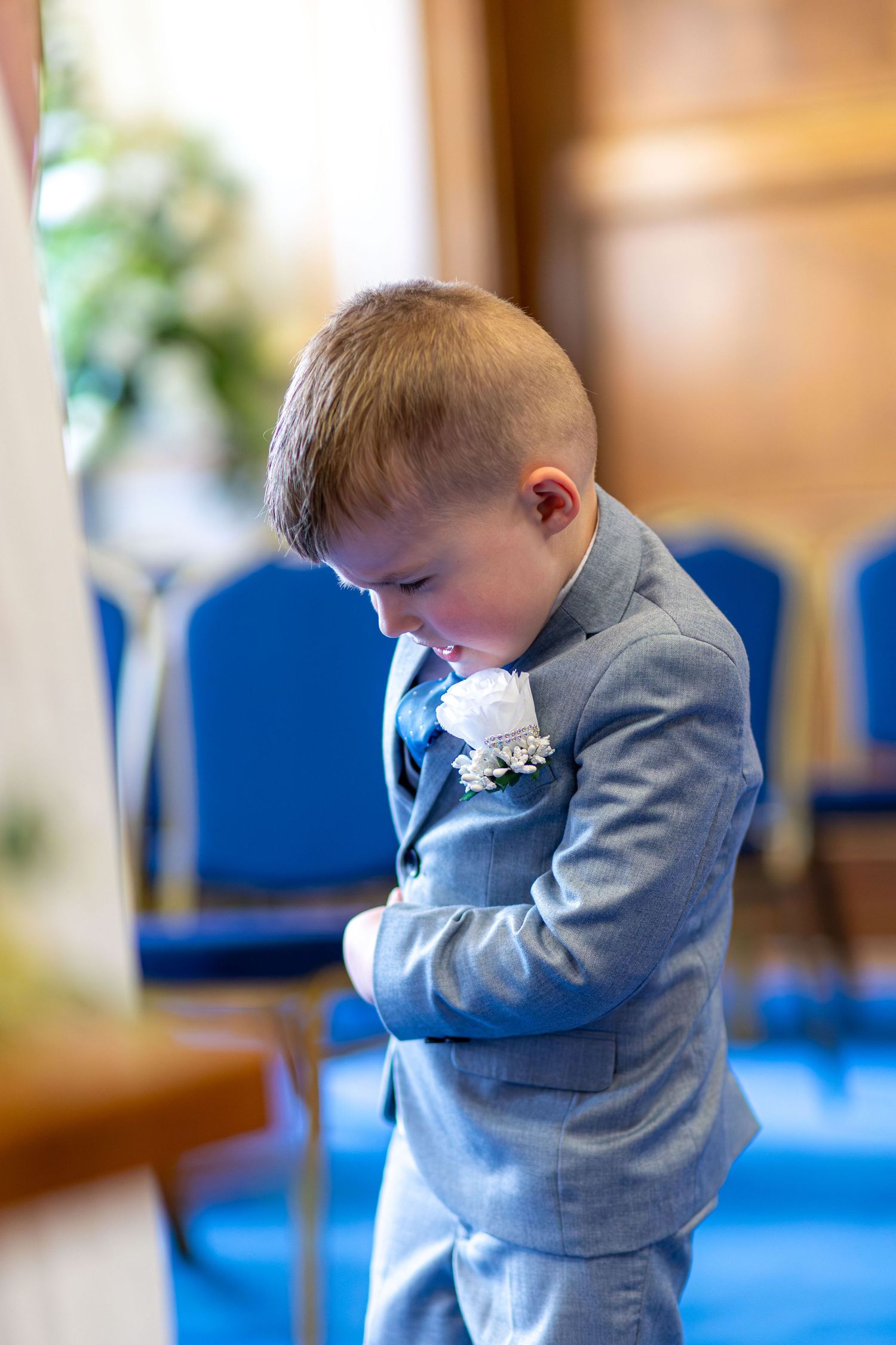 Young page boy standing inside Barnsley Town Hall during the wedding.