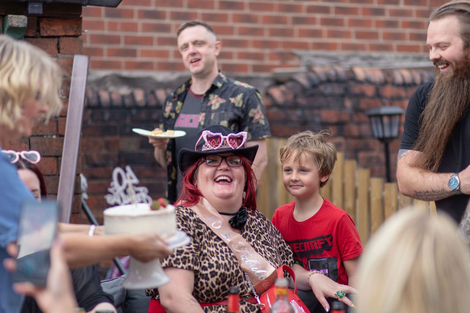 Family and friends celebrating together around the birthday cake at a 40th birthday party