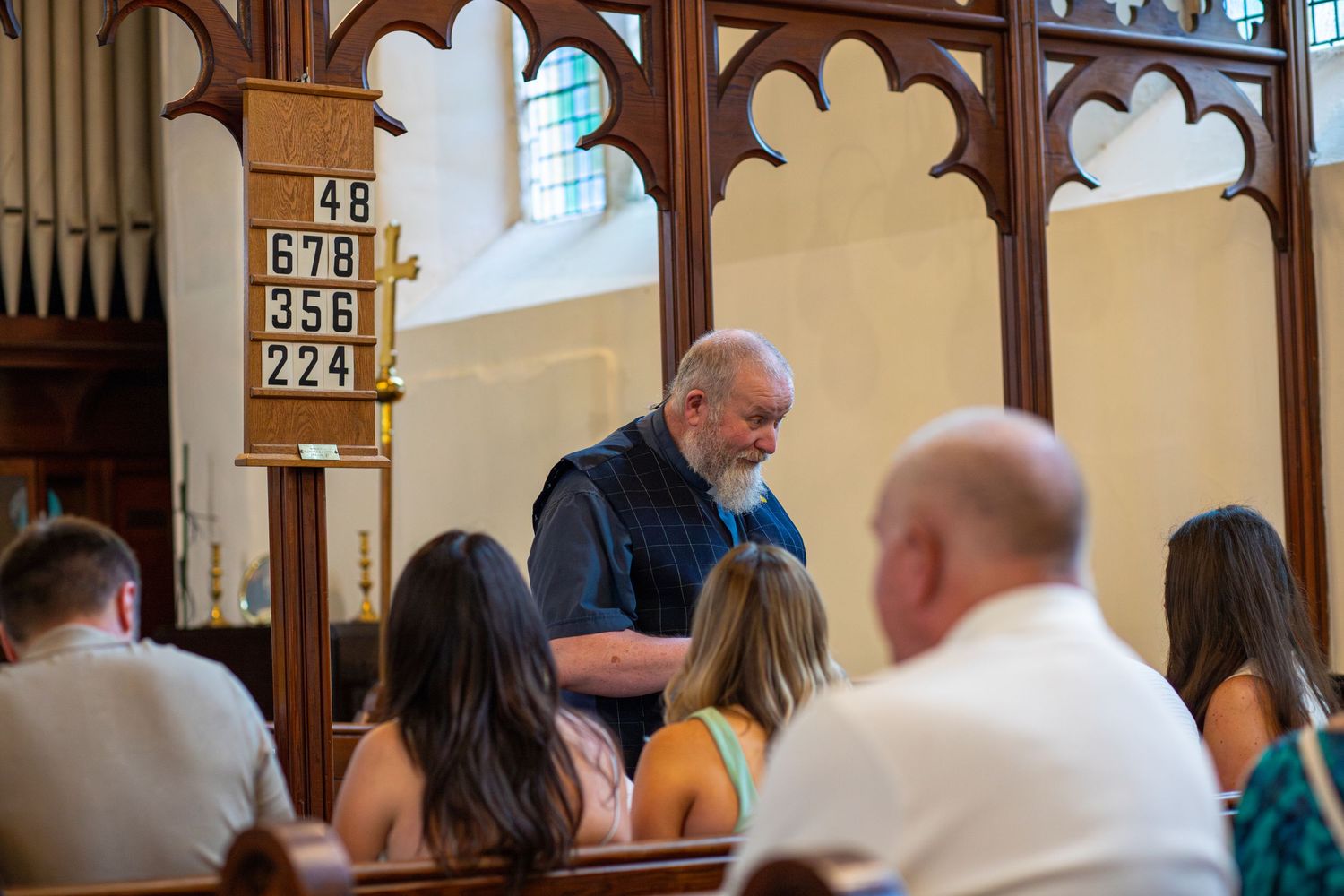 Priest making a speech at a Christening in front of a crowd