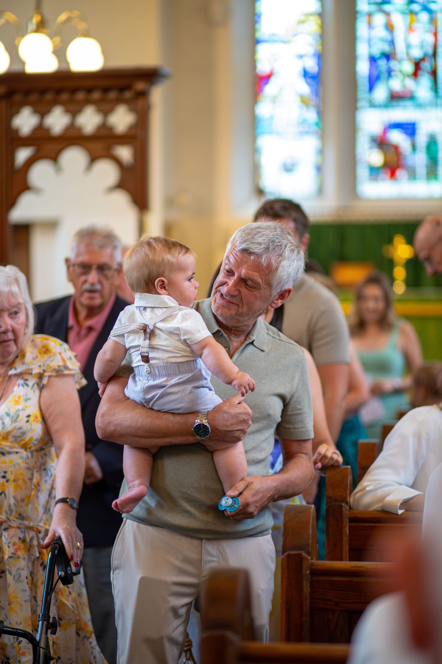 Grandfather holds his Grandson during a church Christening
