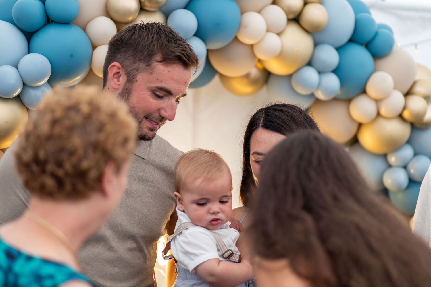 Family and guests gathering around a baby during a christening celebration at St Thomas Church, Barnsley