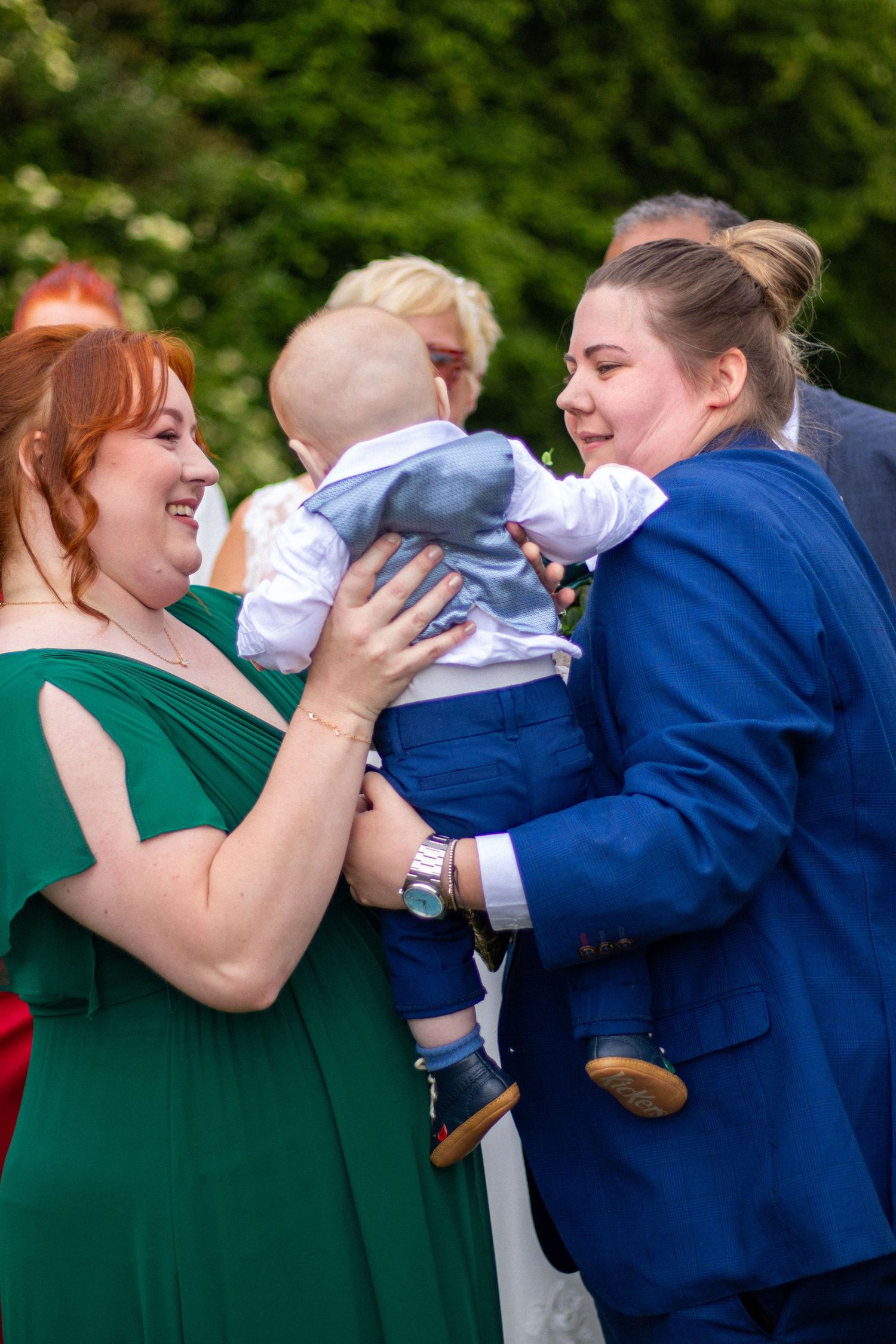 Wedding guest holding a young child at Clifton Park Museum