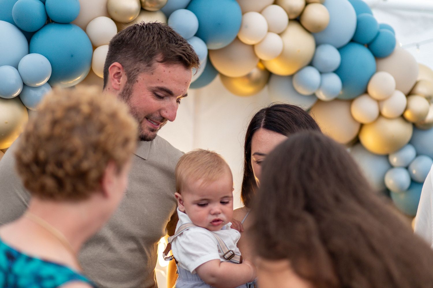Candid family photo of a couple and their baby at a Balloon Christening