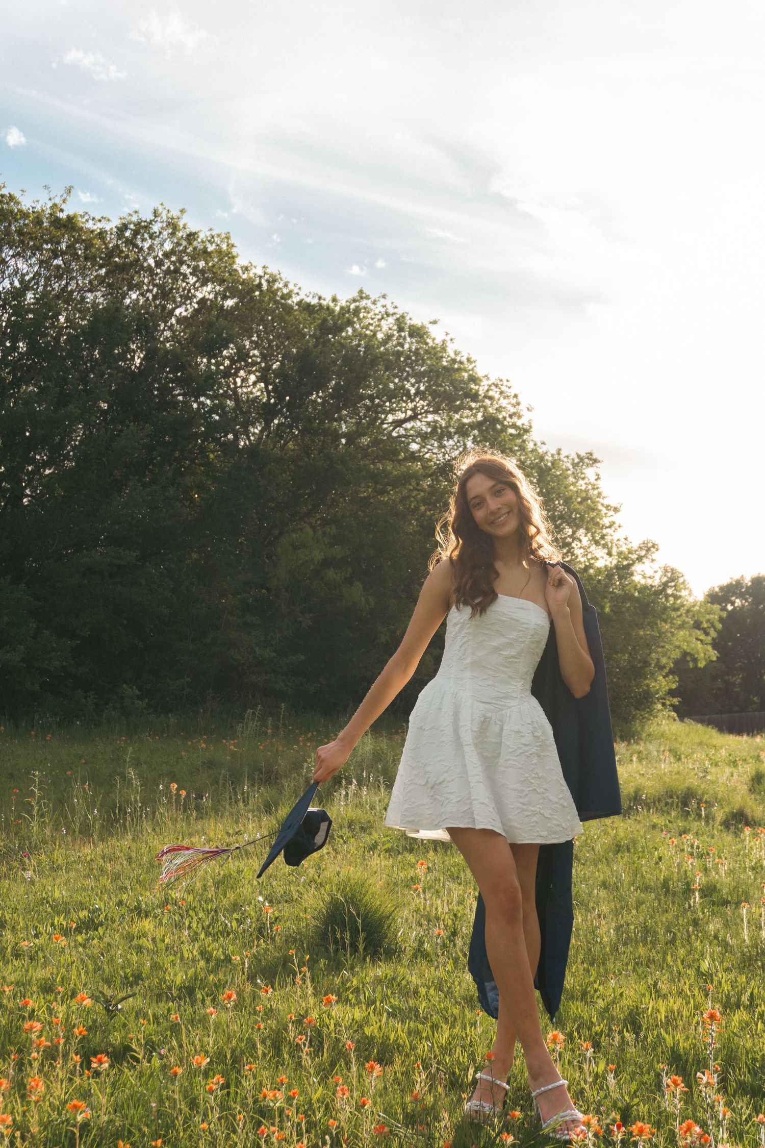 A person in a white dress spins joyfully in a sunlit meadow filled with vibrant wildflowers at golden hour.