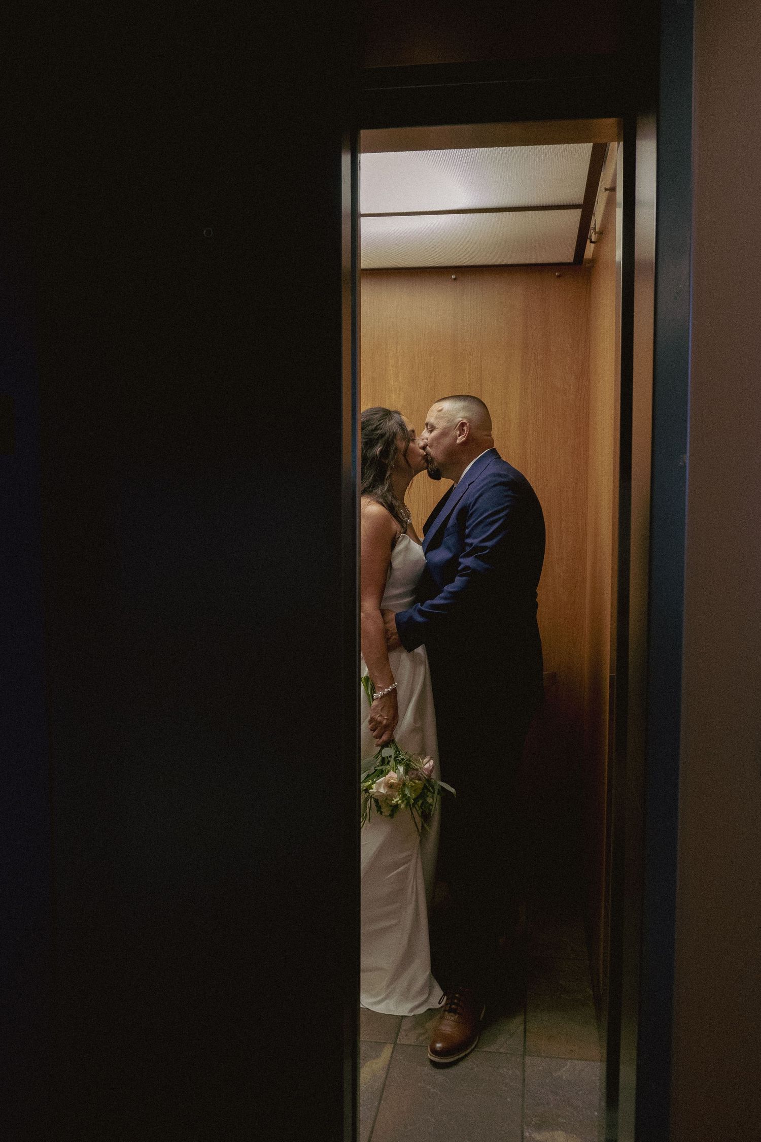 A romantic wedding photography sequence showing a couple embracing in a darkly lit doorway.