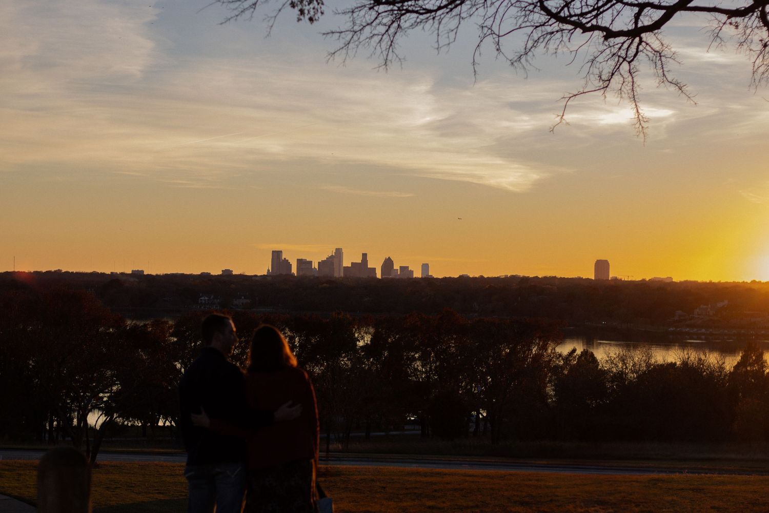 Panoramic sunset cityscape with golden sky and urban buildings on horizon.