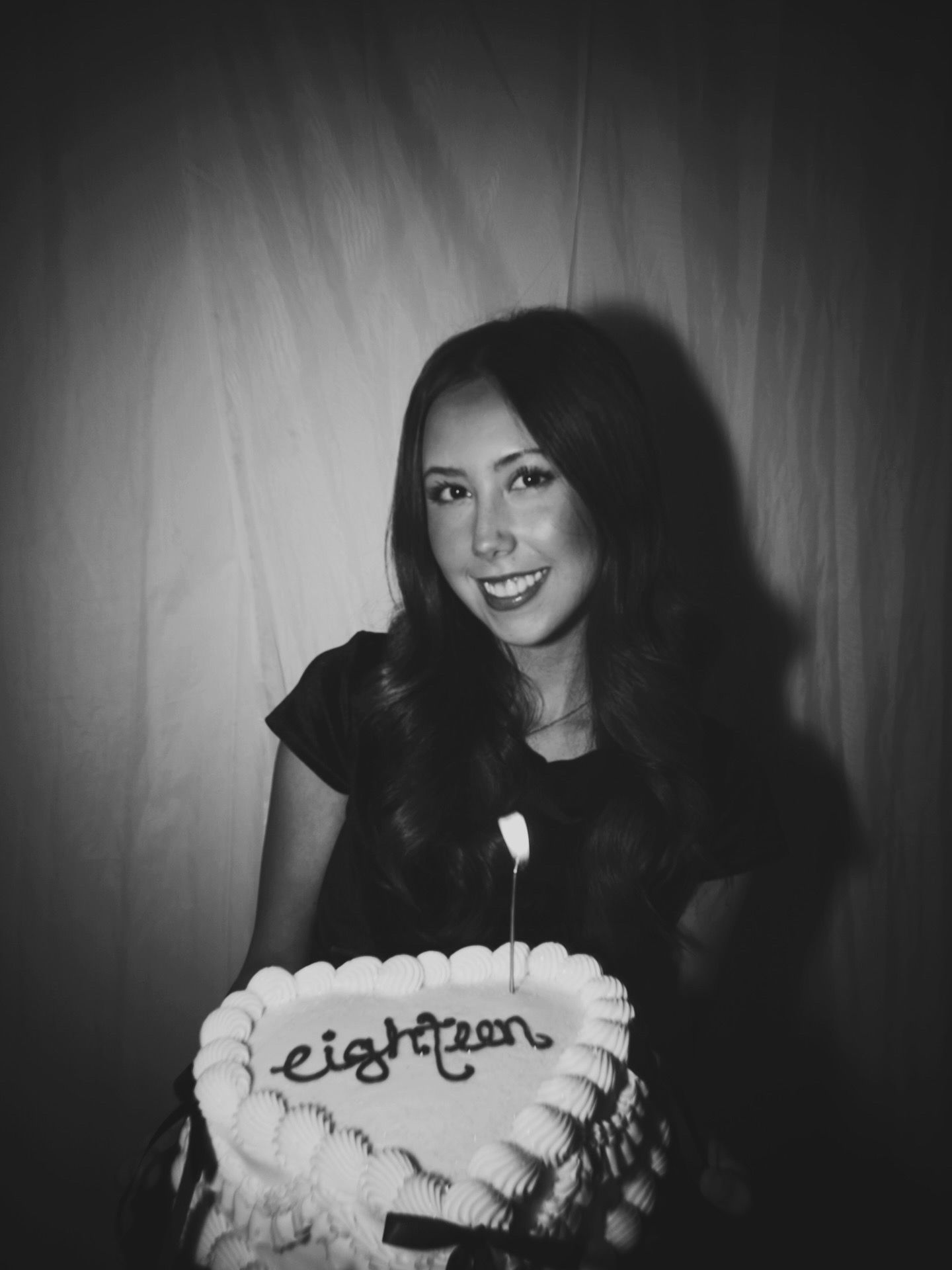 A series of black and white photos showing someone holding a cake with text written in frosting.
