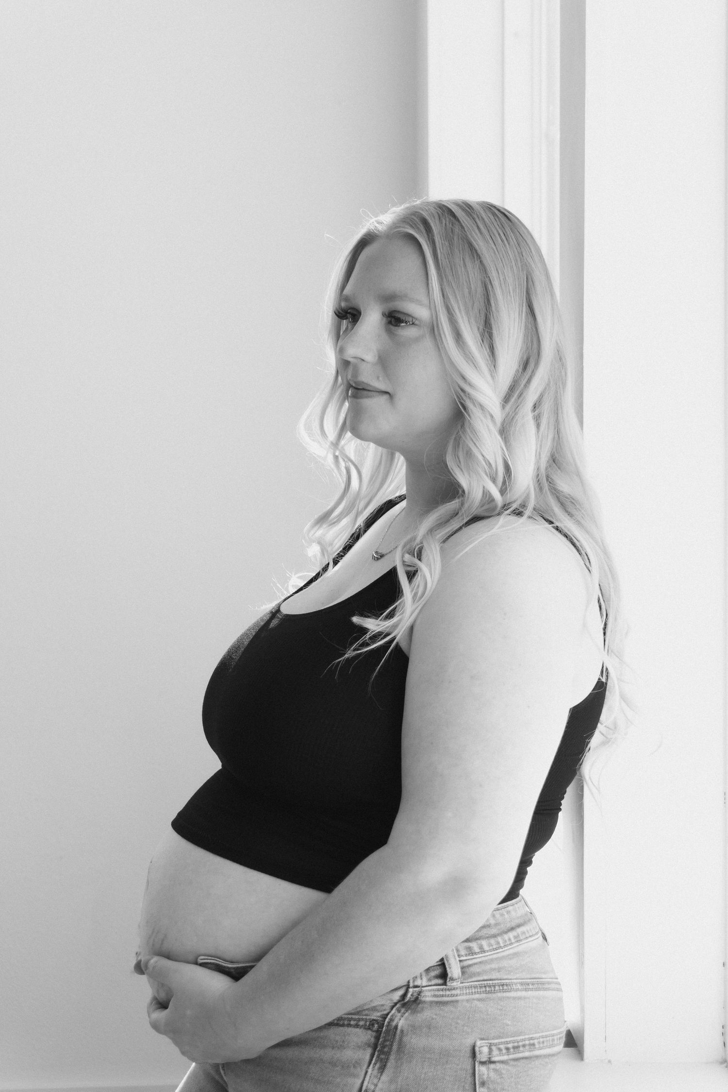 Black and white portrait profile series showing changing intimate poses against white wall.