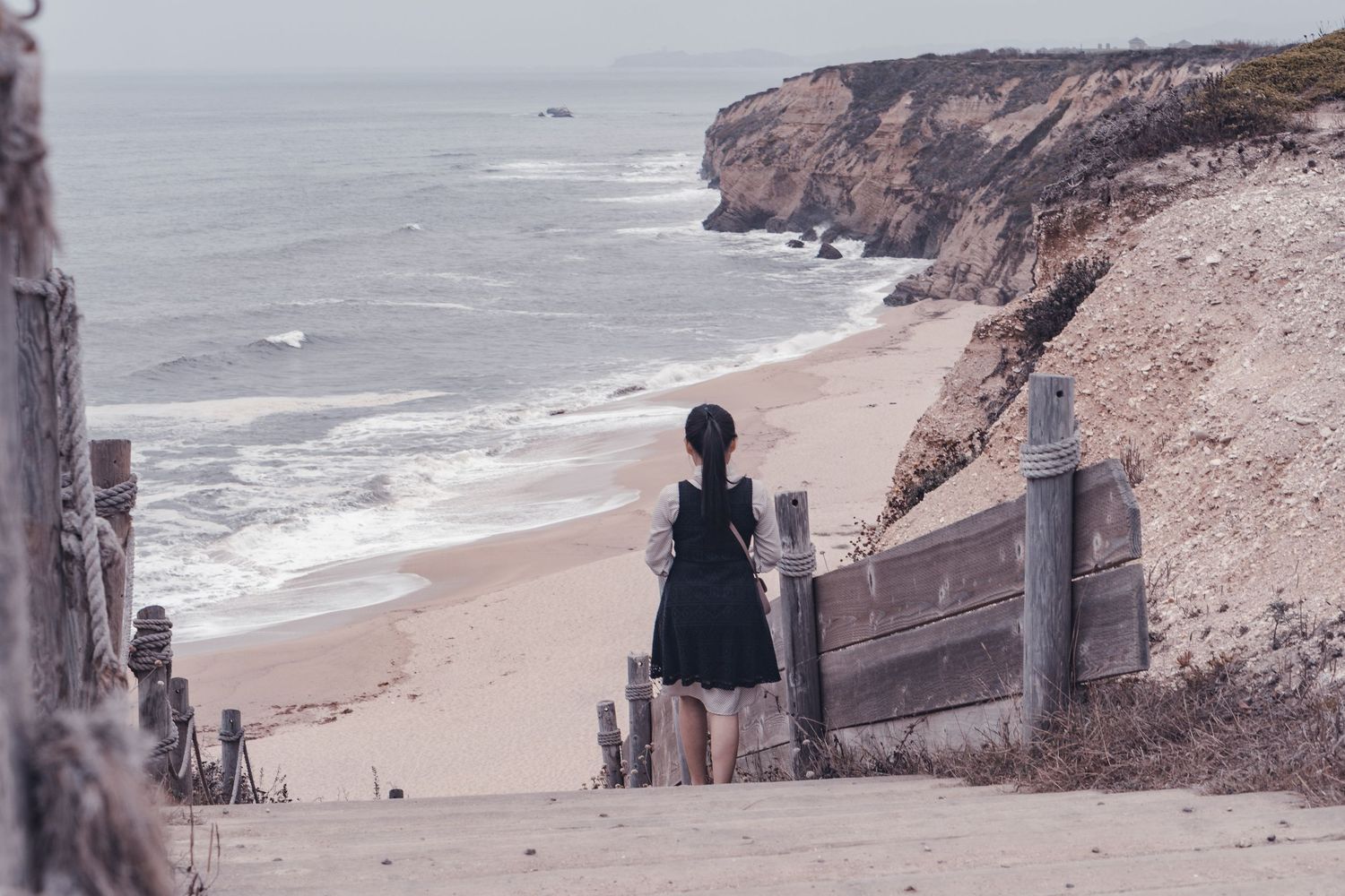 Lady in stairs staring at the beach