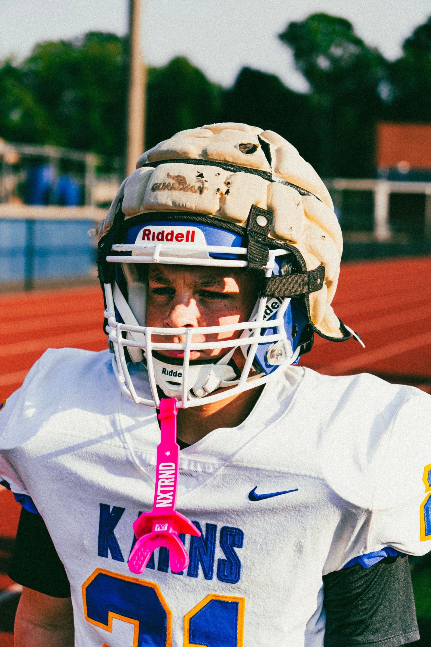 Karns high school football player number 21 in white jersey wearing a worn Riddell helmet.