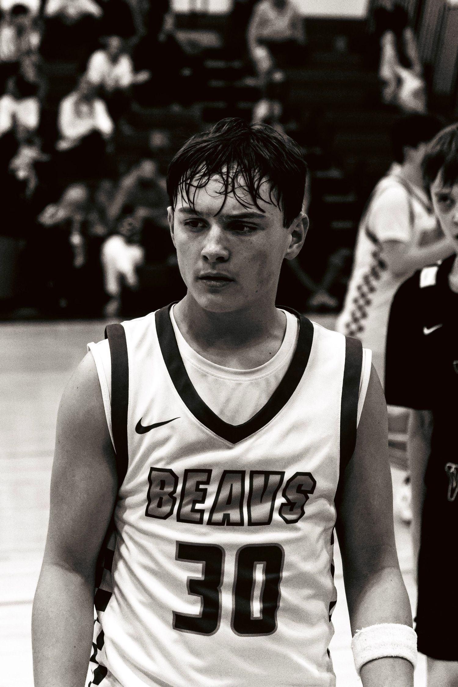 Close-up black and white portrait of sweaty basketball player number 30 in Beavs jersey.