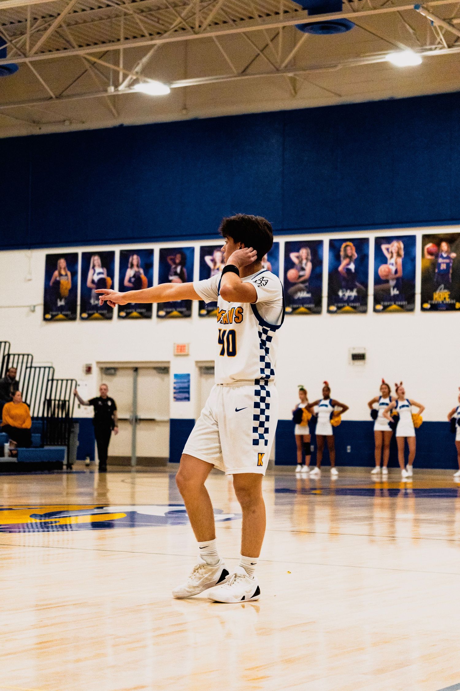 Knox County basketball player number 40 gestures on court with cheerleaders visible in the background.