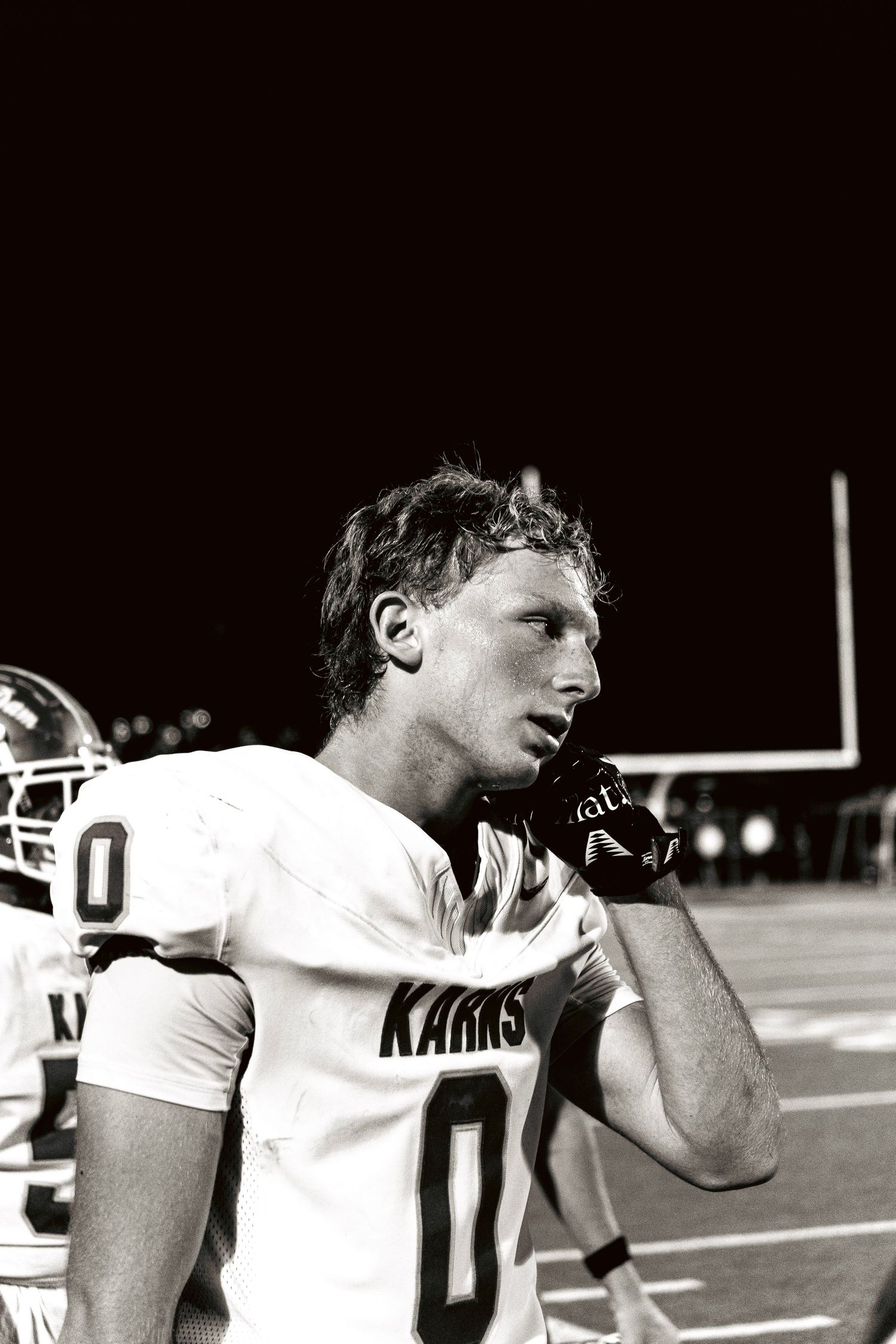 Black and white photo of a Karns football player in jersey number 0 on the sideline.