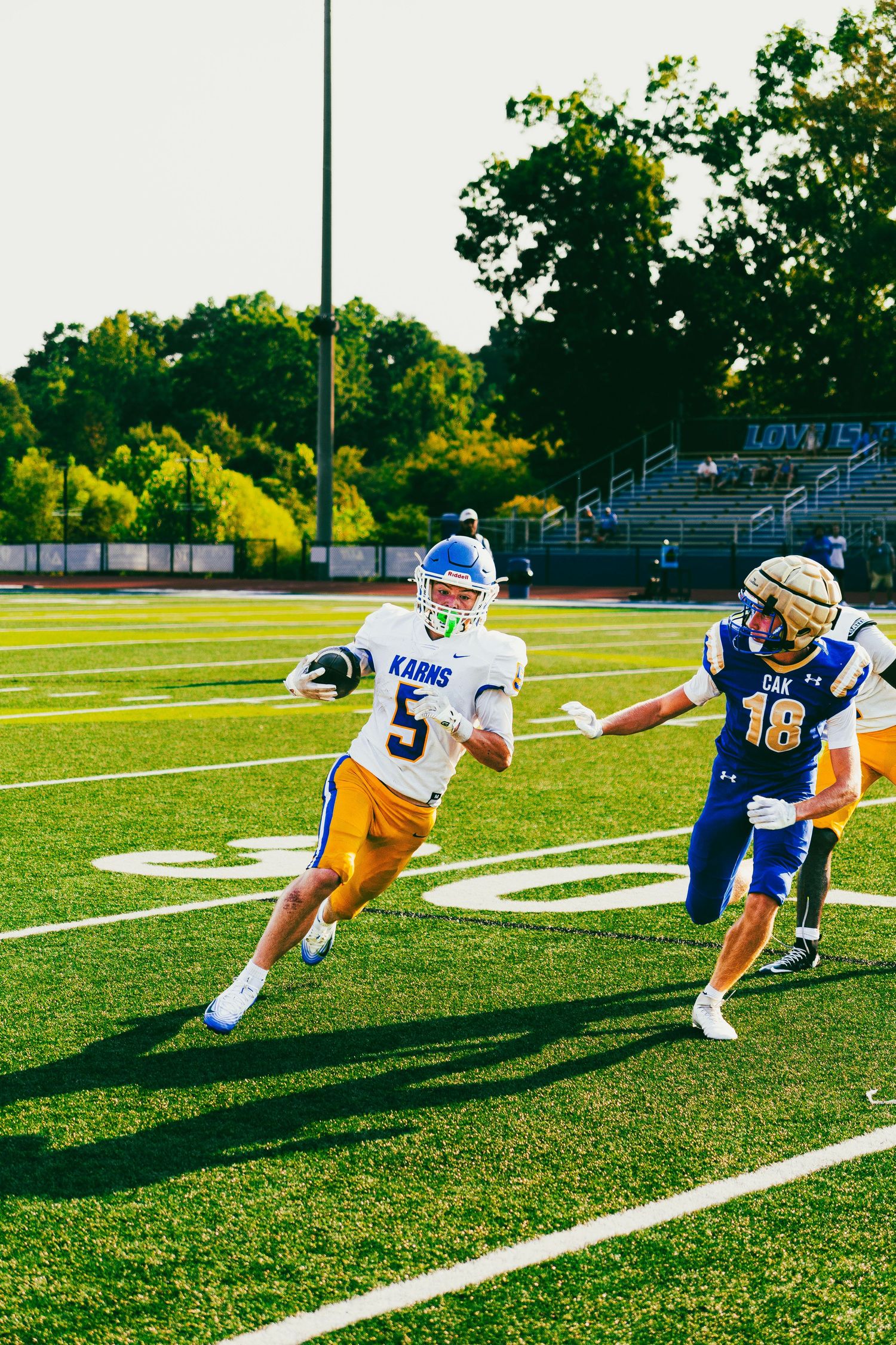 Karns football player number 5 running with ball during a high school game.