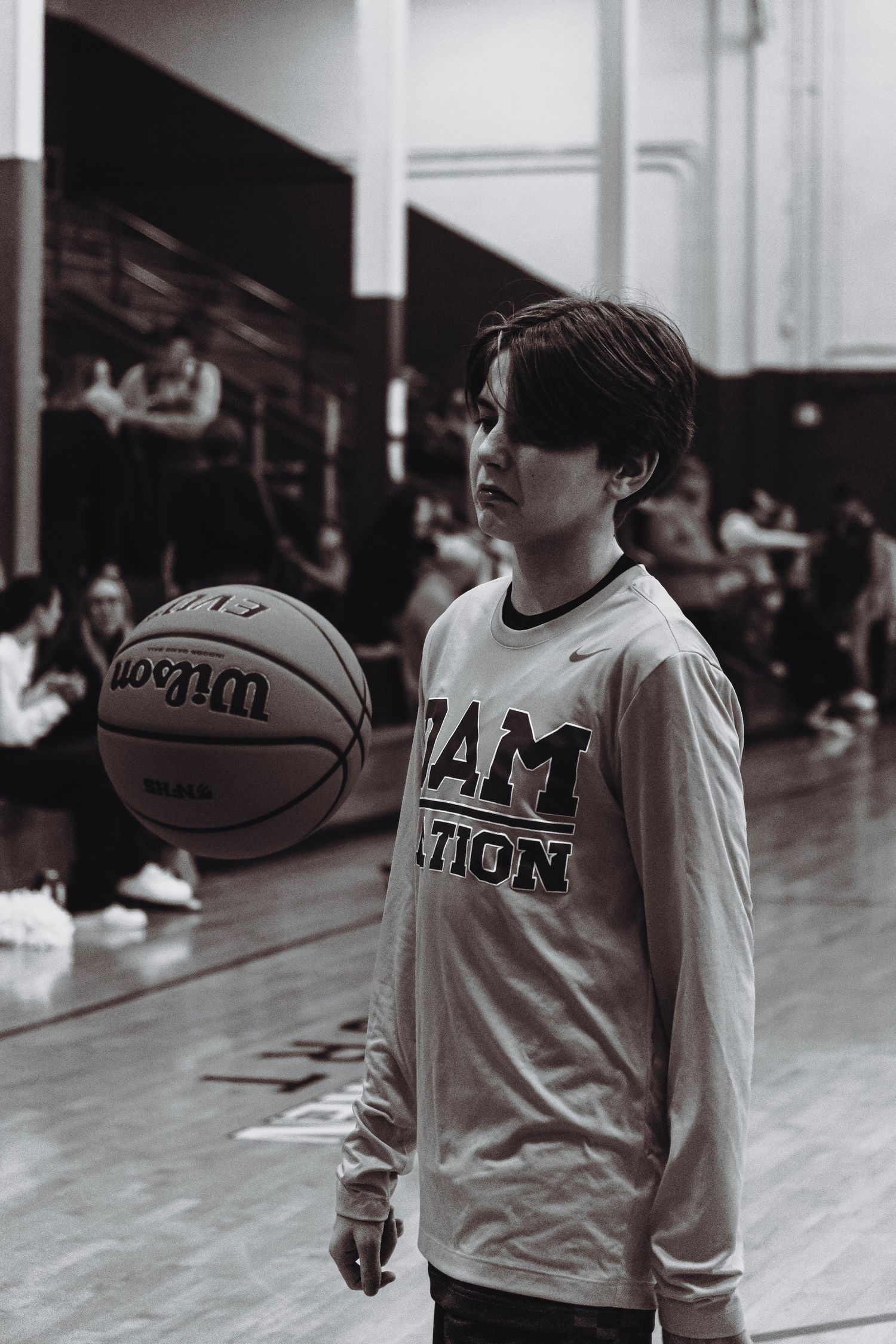 A young basketball player in a RAM Nation jersey holding a Wilson basketball.