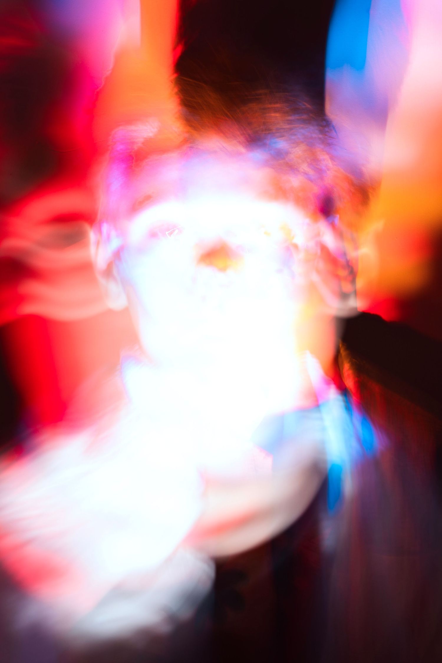 Abstract colorful motion blur portrait with vibrant red and blue lights.