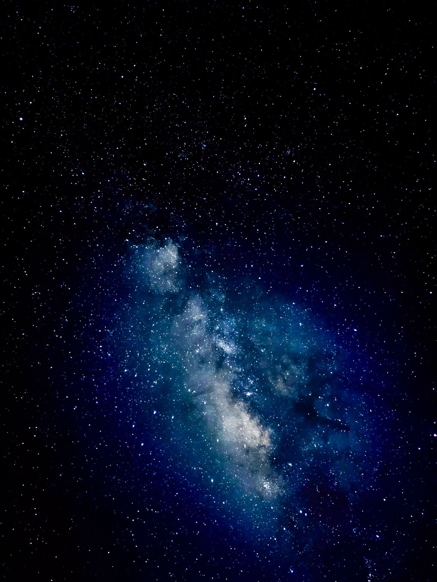 Stunning Milky Way galaxy with vibrant blue and white star clusters against a dark night sky.