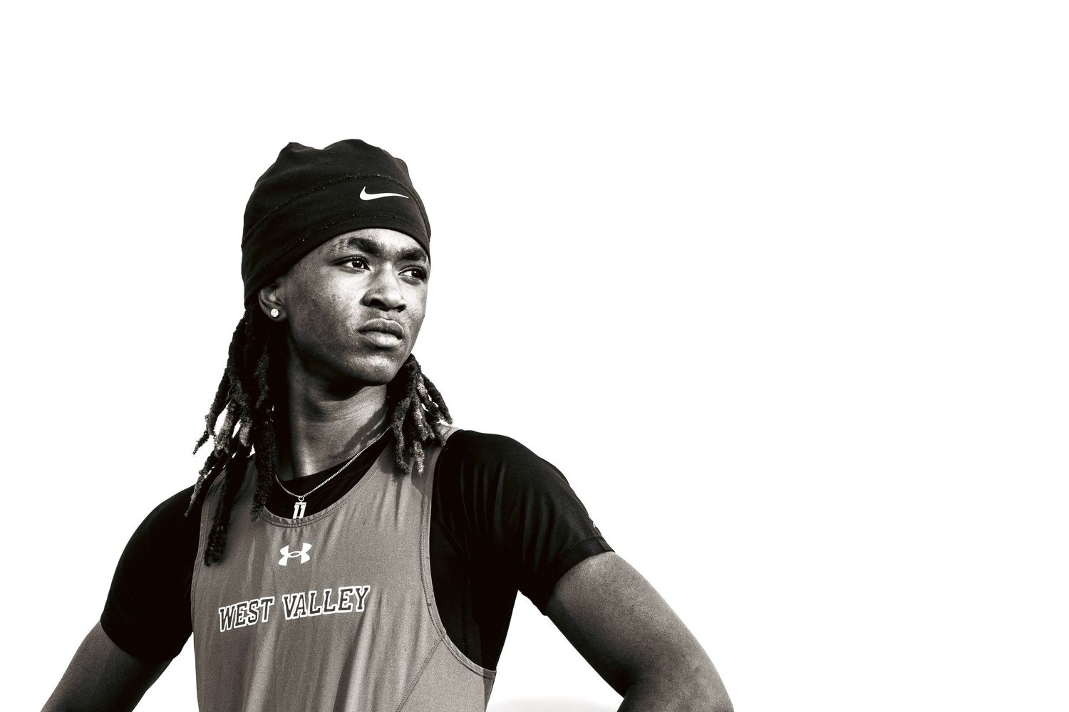 Black and white photo of a young male athlete wearing a Nike beanie and Under Armour shirt.