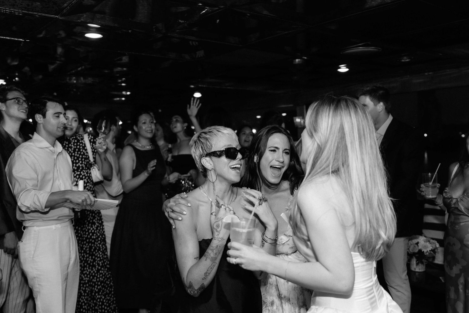 Dark nightclub scene with people dancing and socializing.