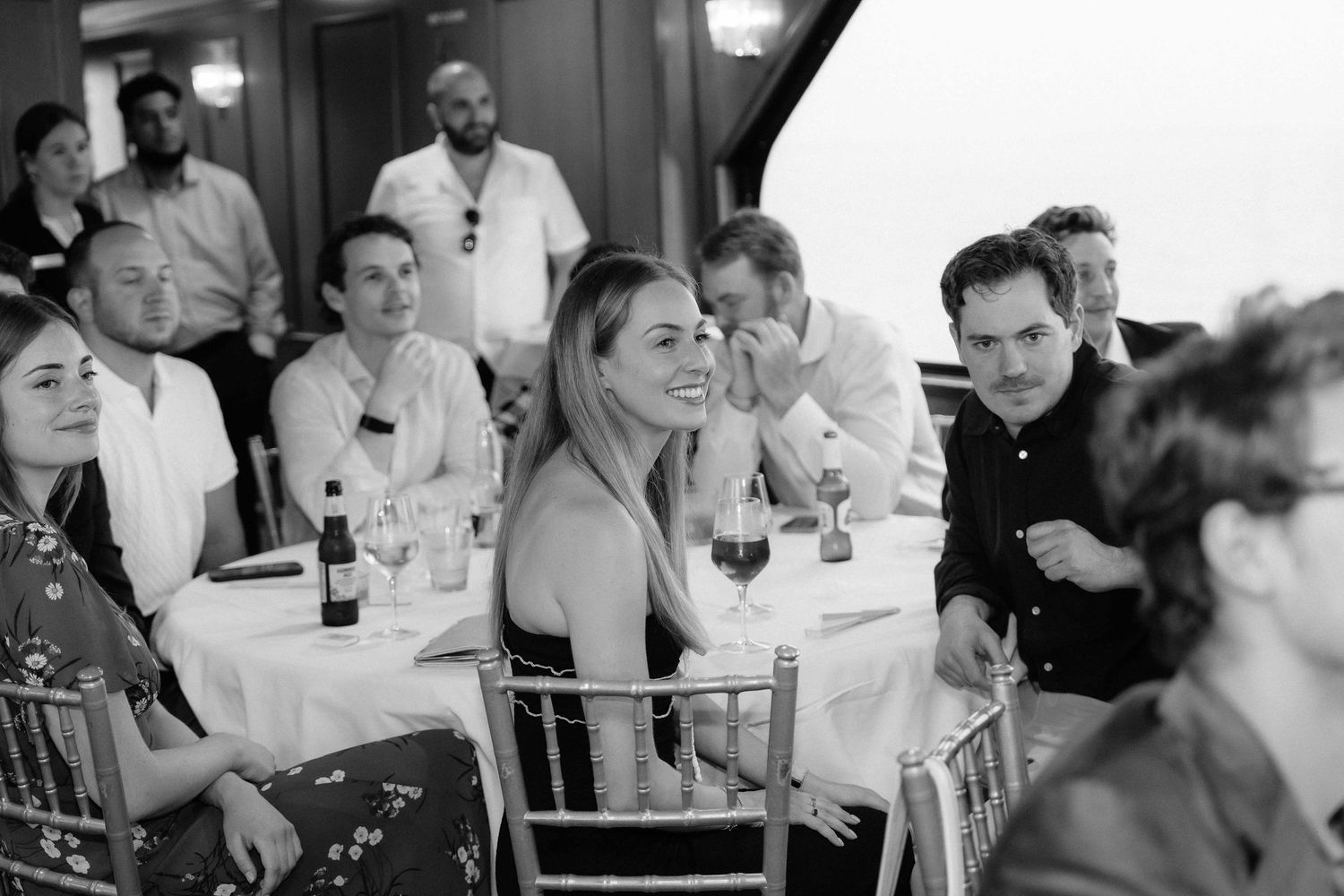 Black and white photo of guests socializing at a casual dining event.