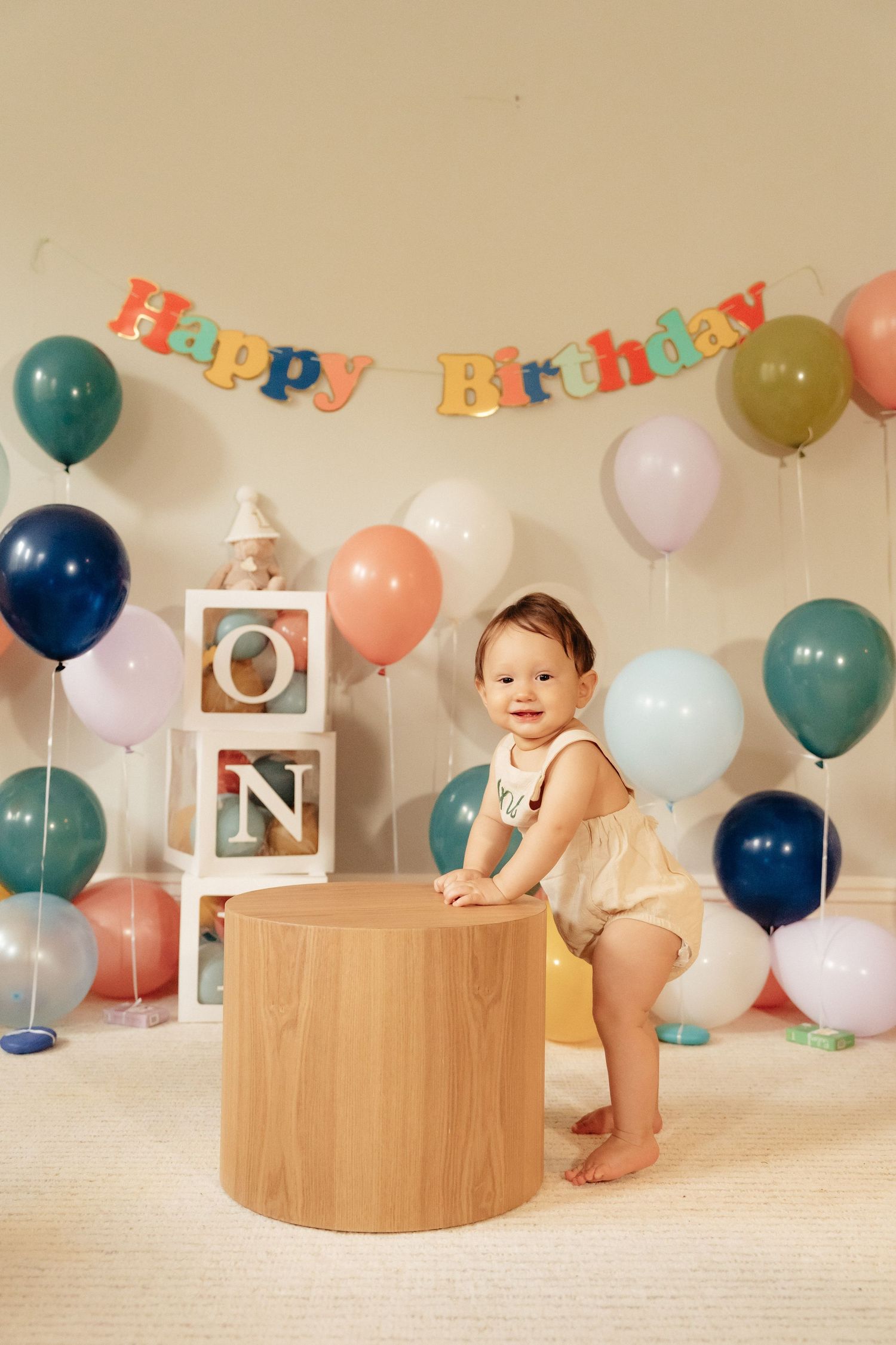 Birthday celebration scene with wooden platforms, colorful balloons, and 'Happy Birthday' banner.