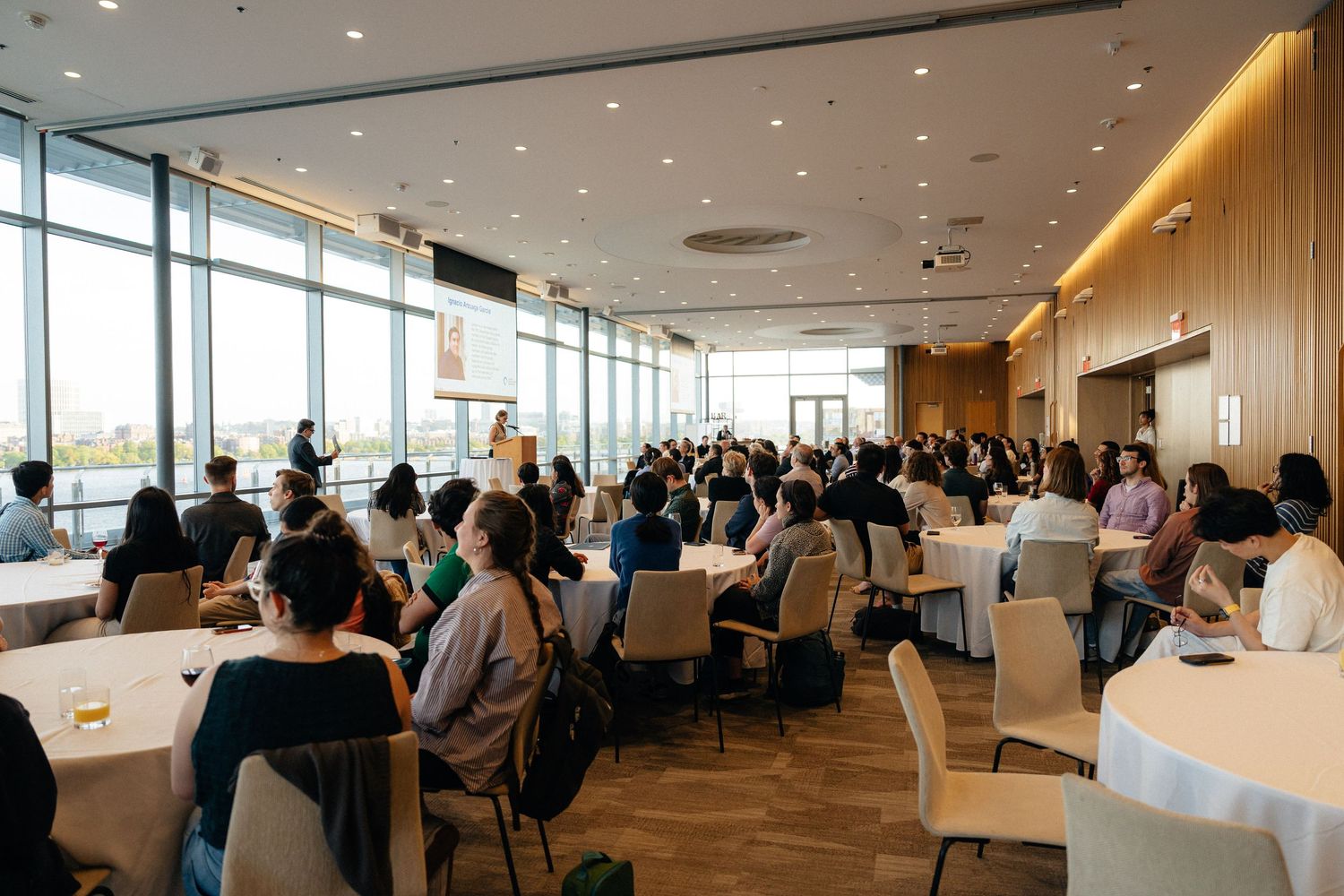 Panoramic view of a corporate conference room with attendees seated in rows.
