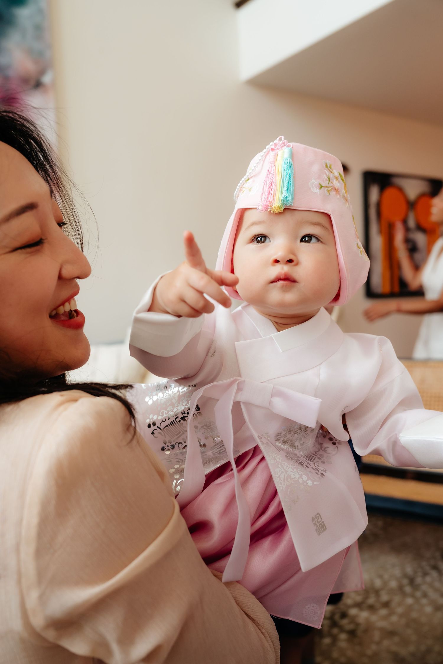 Intimate moment captured in soft lighting with pink clothing and gentle expressions.