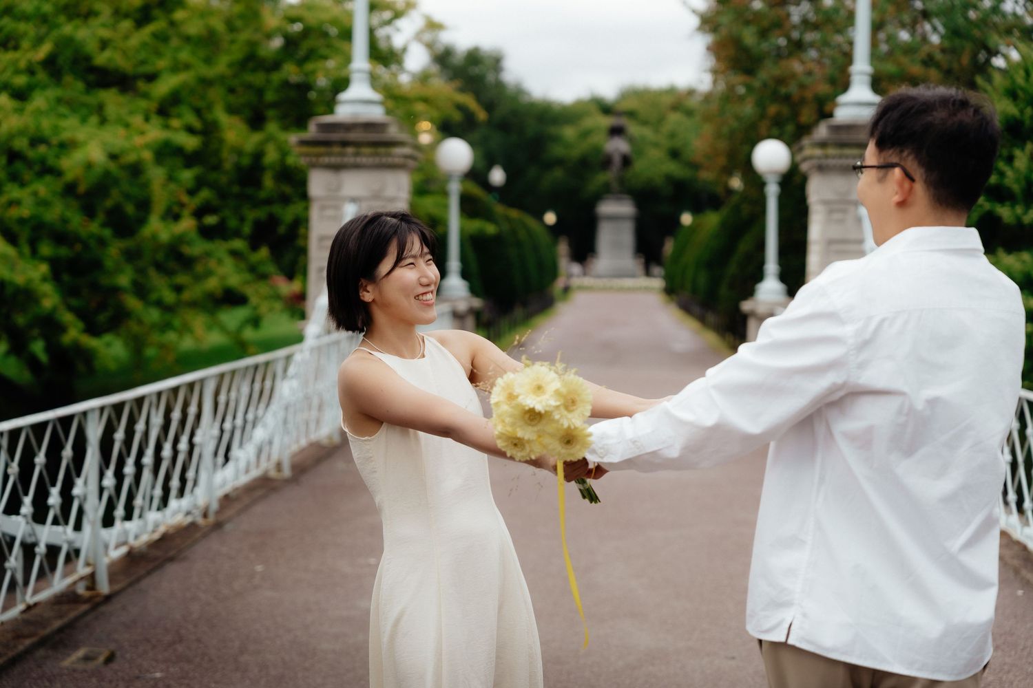 Boston Public Garden engagement photo with the couple on the bridge
