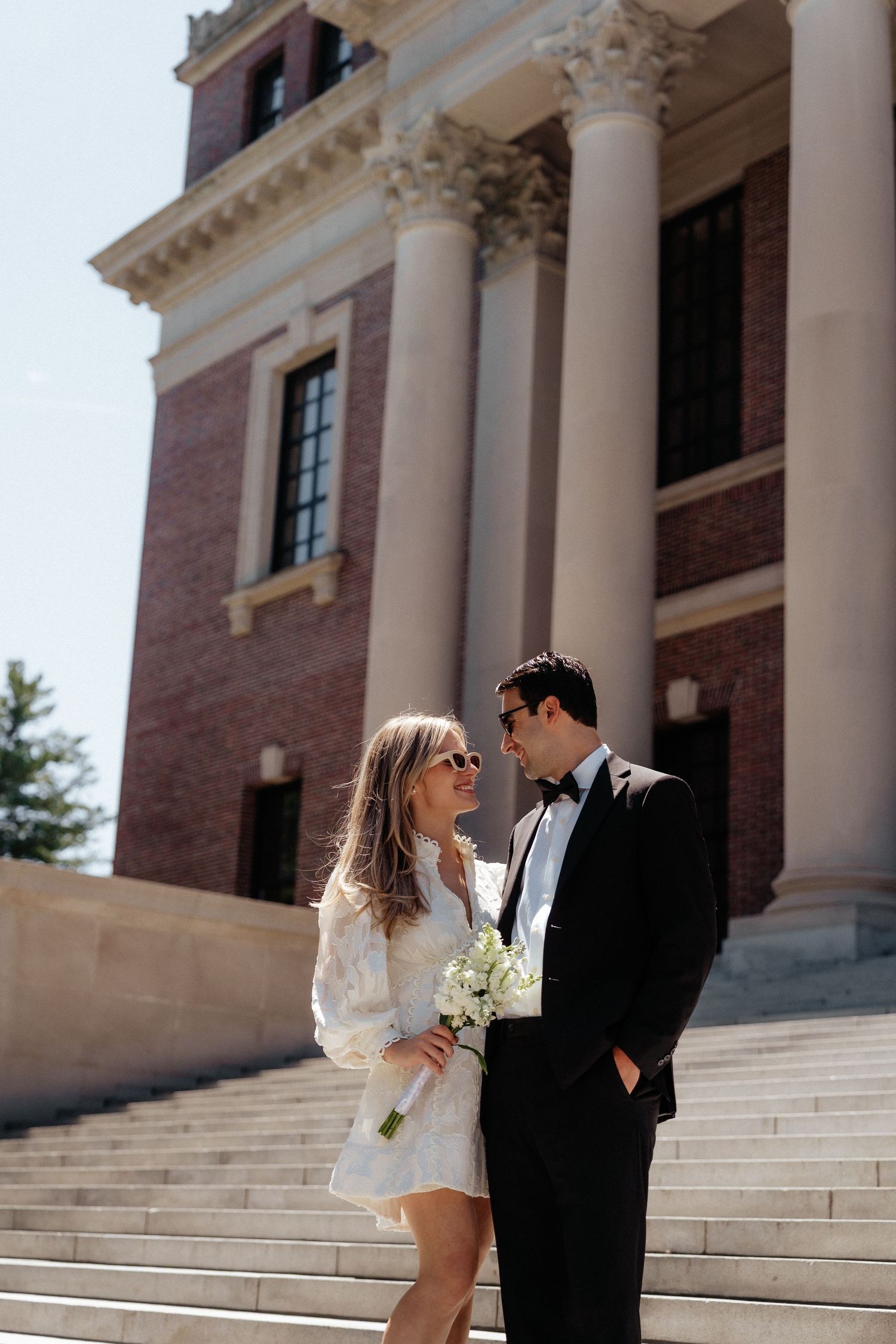 Classic architectural columns and white steps create elegant backdrop for formal portraits.