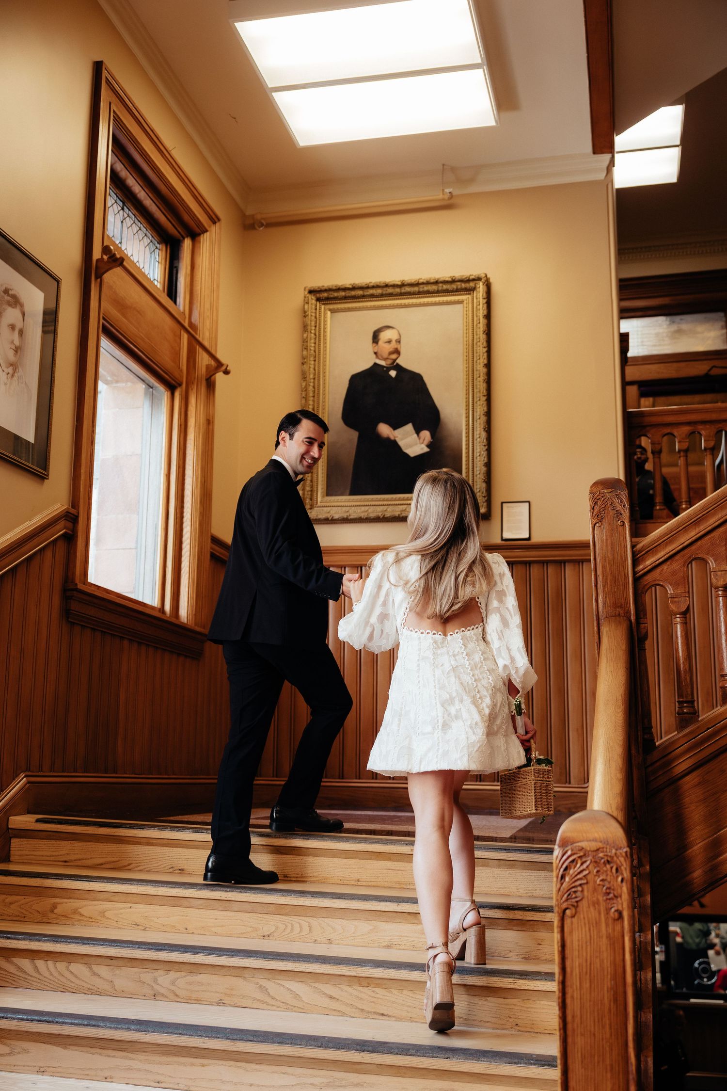A series of romantic moments captured on an elegant wooden staircase with warm interior lighting.