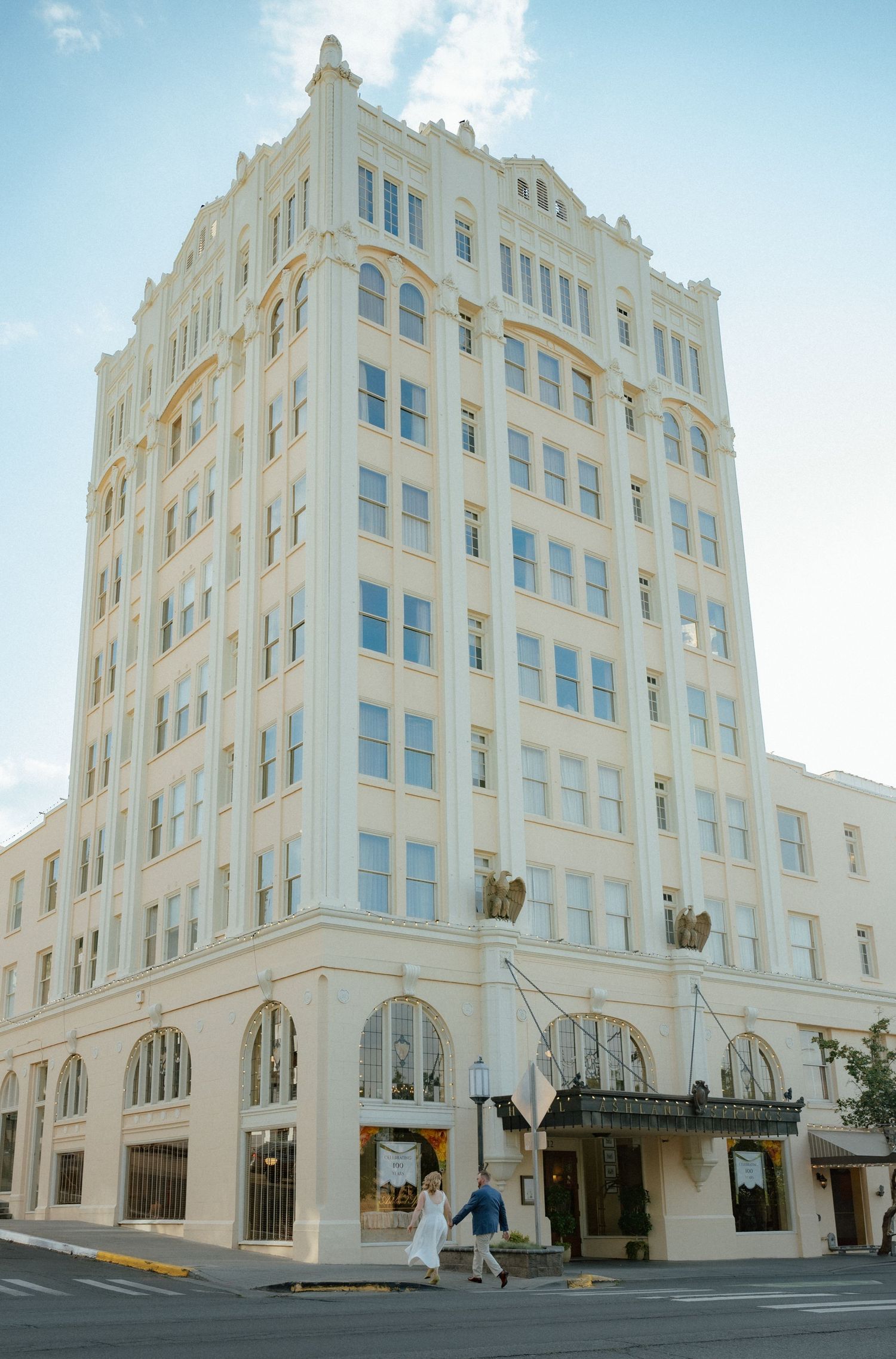 Architectural shots of a grand white art deco building against a blue sky.