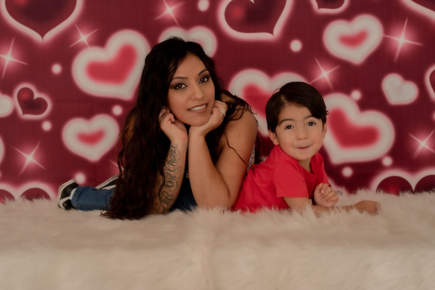 Family portrait series with red heart backdrop and soft lighting effects.