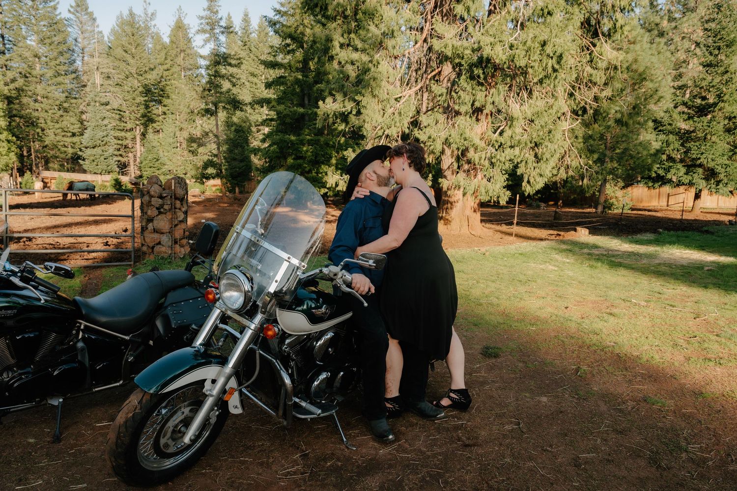 A motorcycle parked in a forest clearing during a sunny afternoon.
