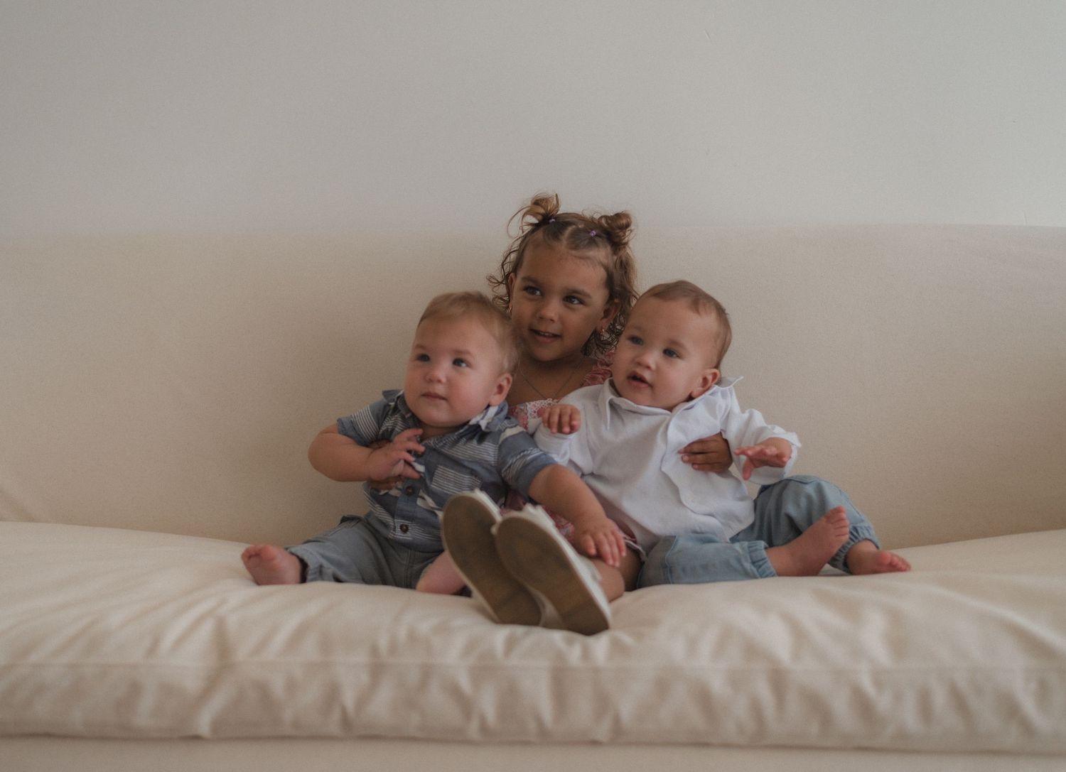 Cozy family scene with multiple people relaxing on white furniture.