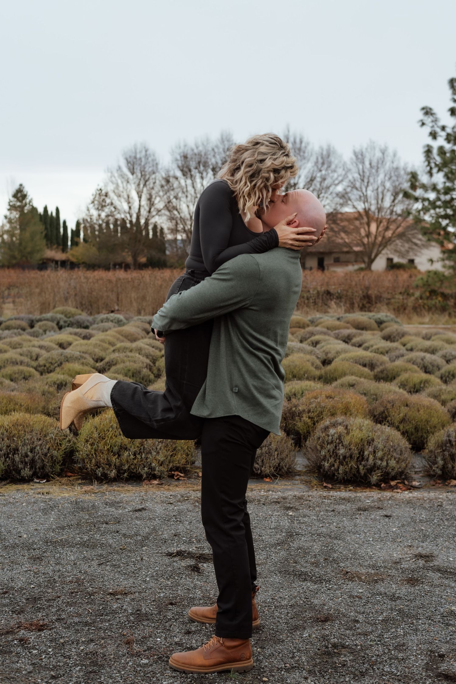 Romantic couple sharing intimate moment in garden setting during engagement photoshoot.