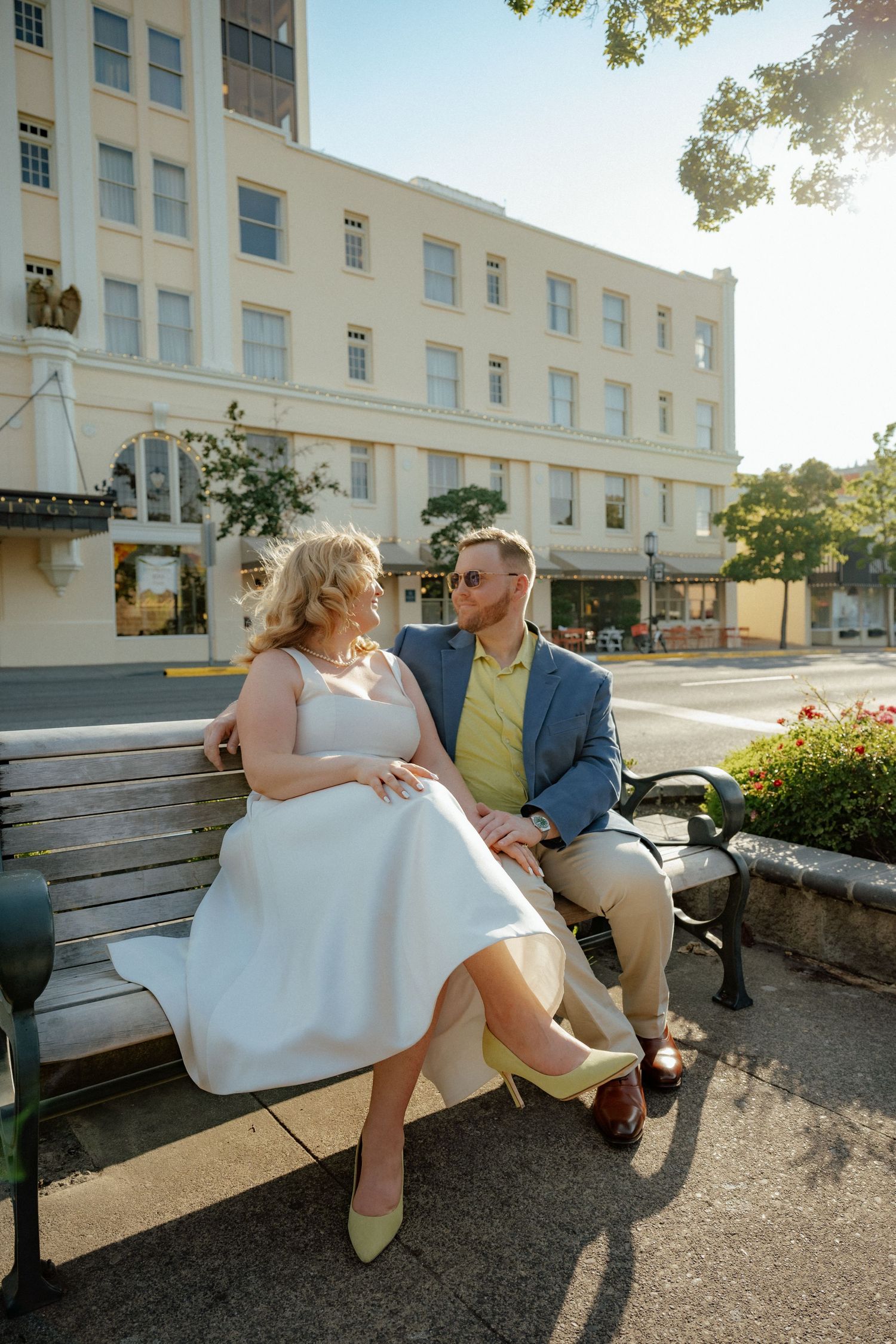 A romantic moment captured on a park bench during golden hour.