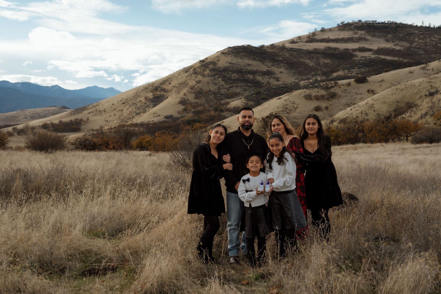 Group gathers for photos in a scenic mountain landscape during autumn.