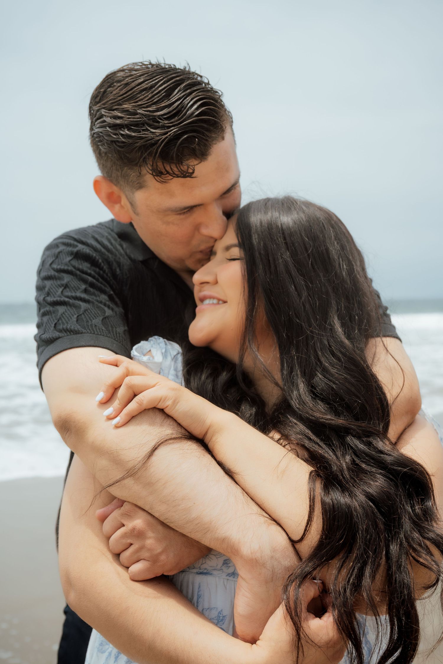 Romantic sequence of a couple sharing intimate moments on a cloudy beach.
