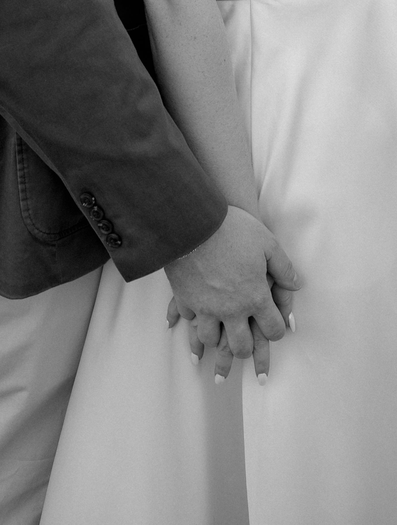 Black and white detail shot of hands against white fabric.