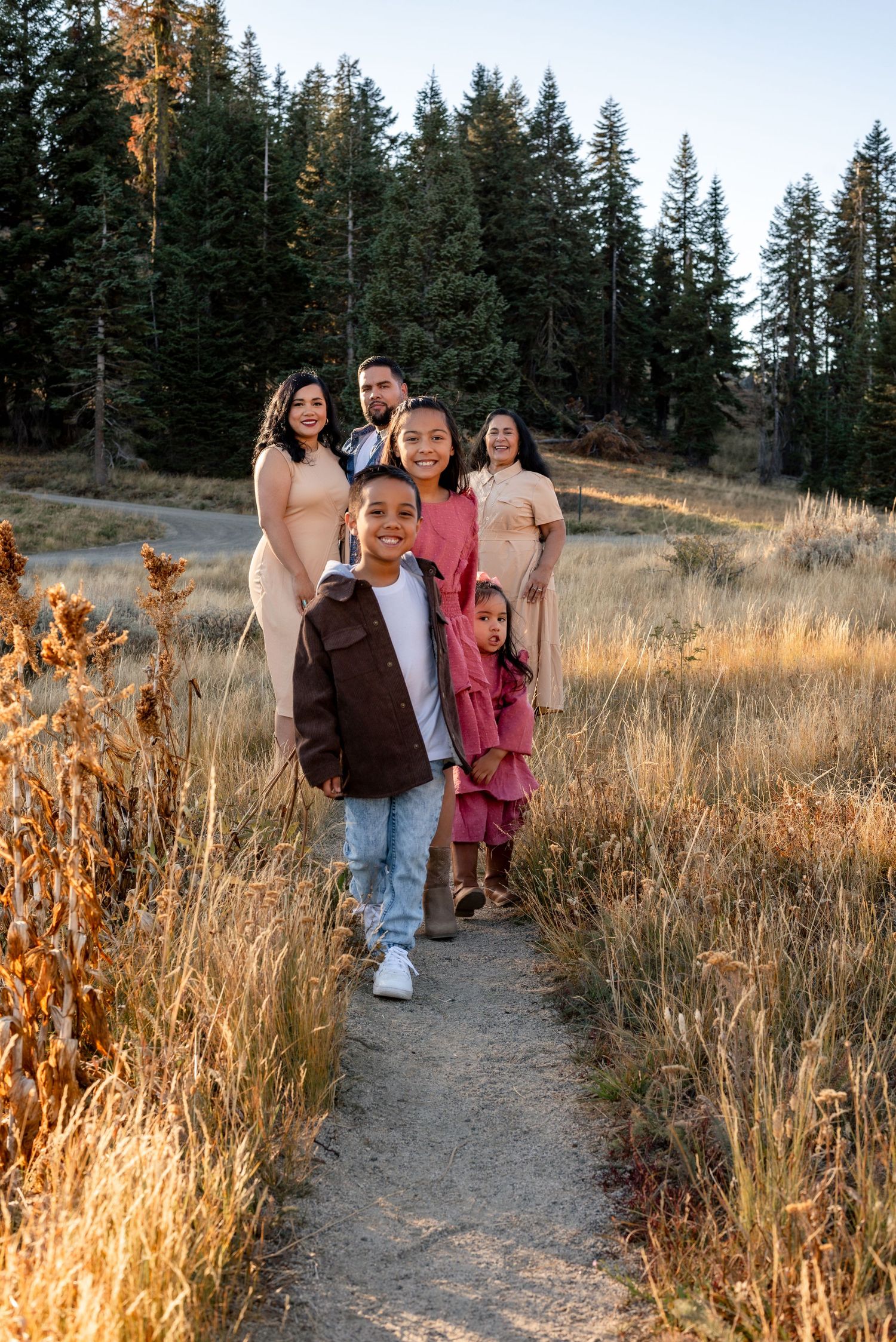 Family enjoying time together on a mountain trail during golden hour.