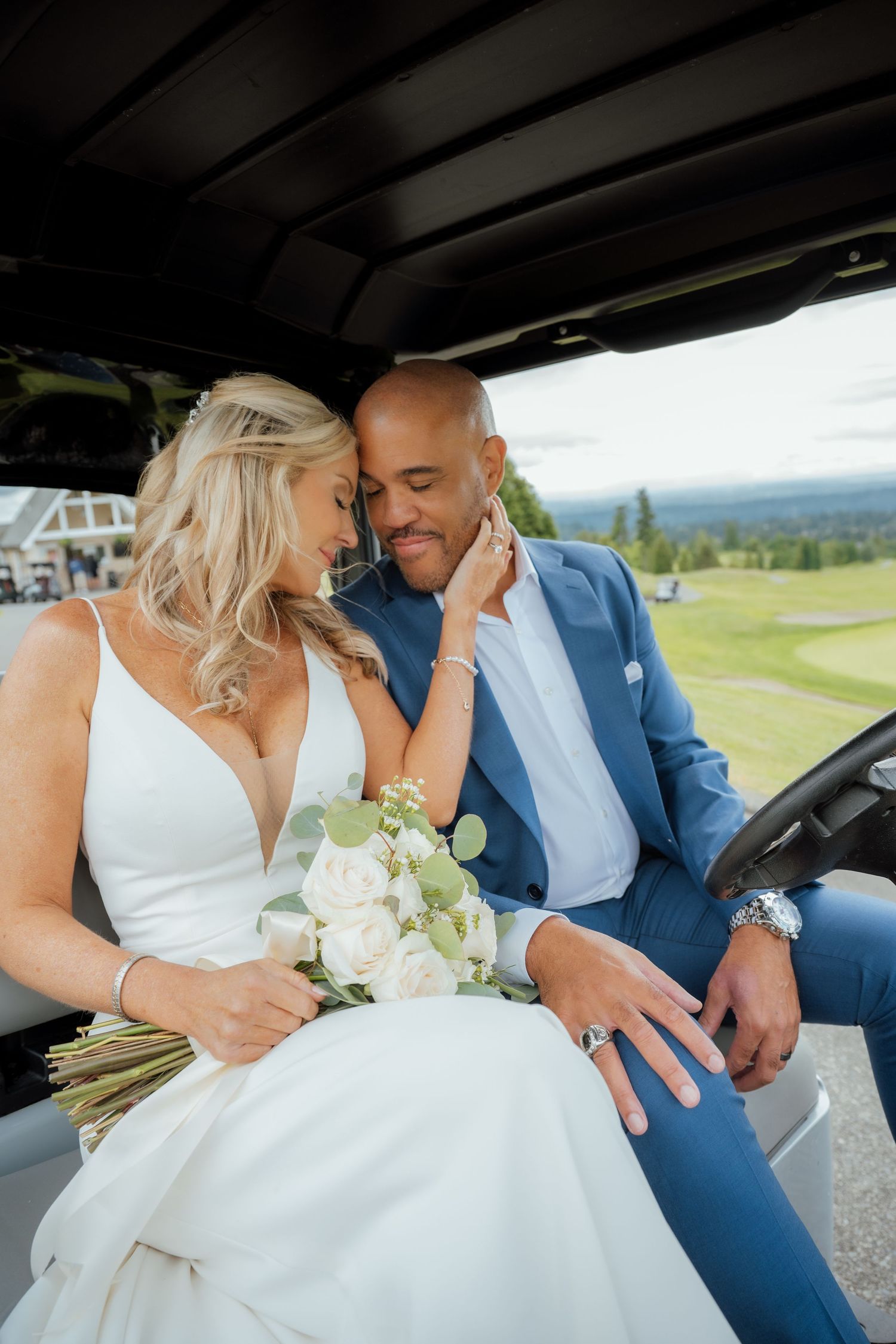 A tender moment between newlyweds in formal attire inside a golf cart.
