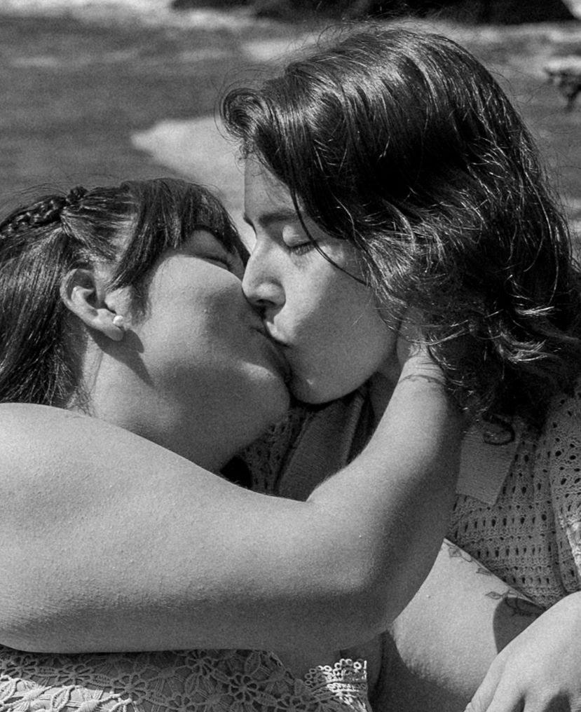 Black and white intimate portrait of two people sharing a tender moment.