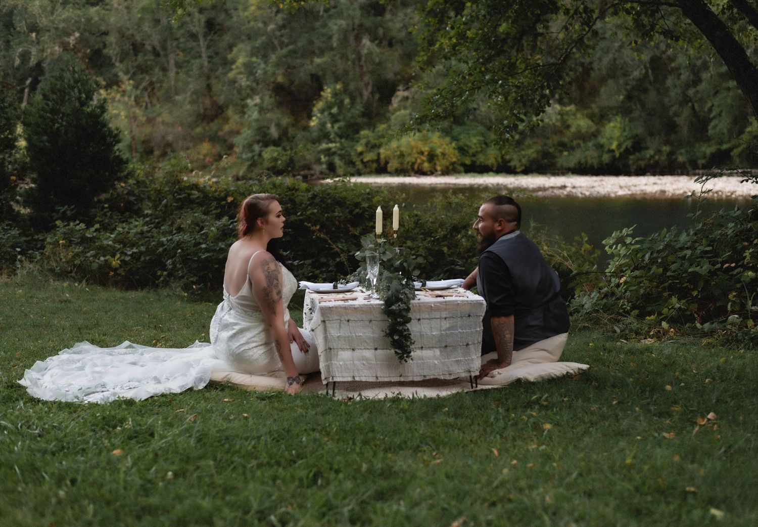 Couple relaxing on blankets in a lush garden setting.