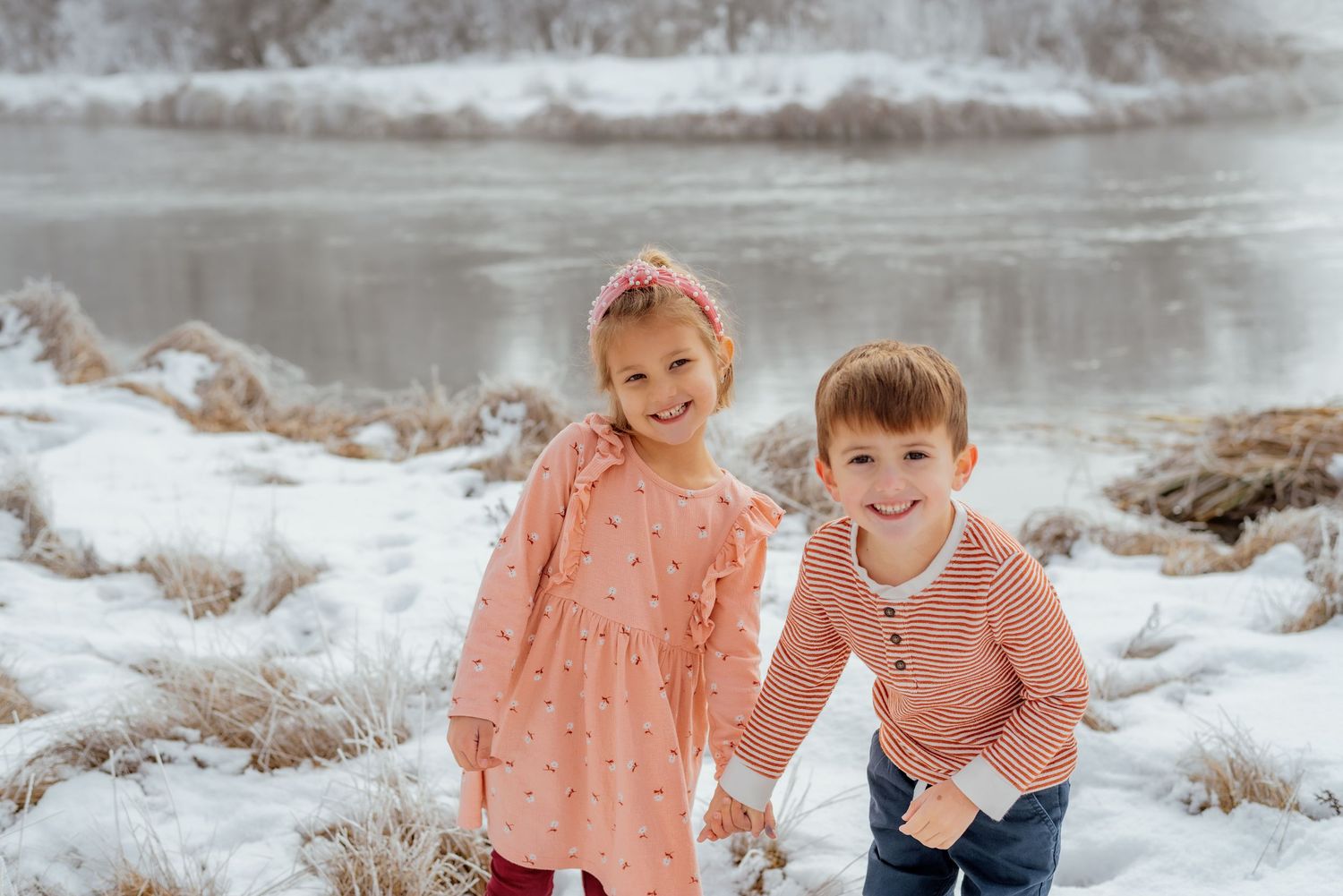 Snowy landscape family photos with frozen lake and winter scenery.