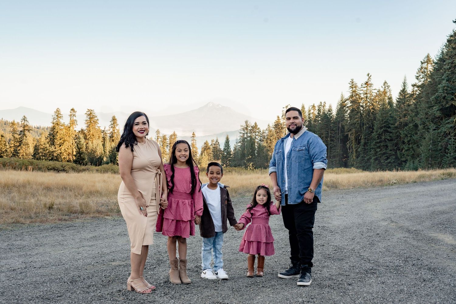 Family walking together on a scenic mountain trail during golden hour.