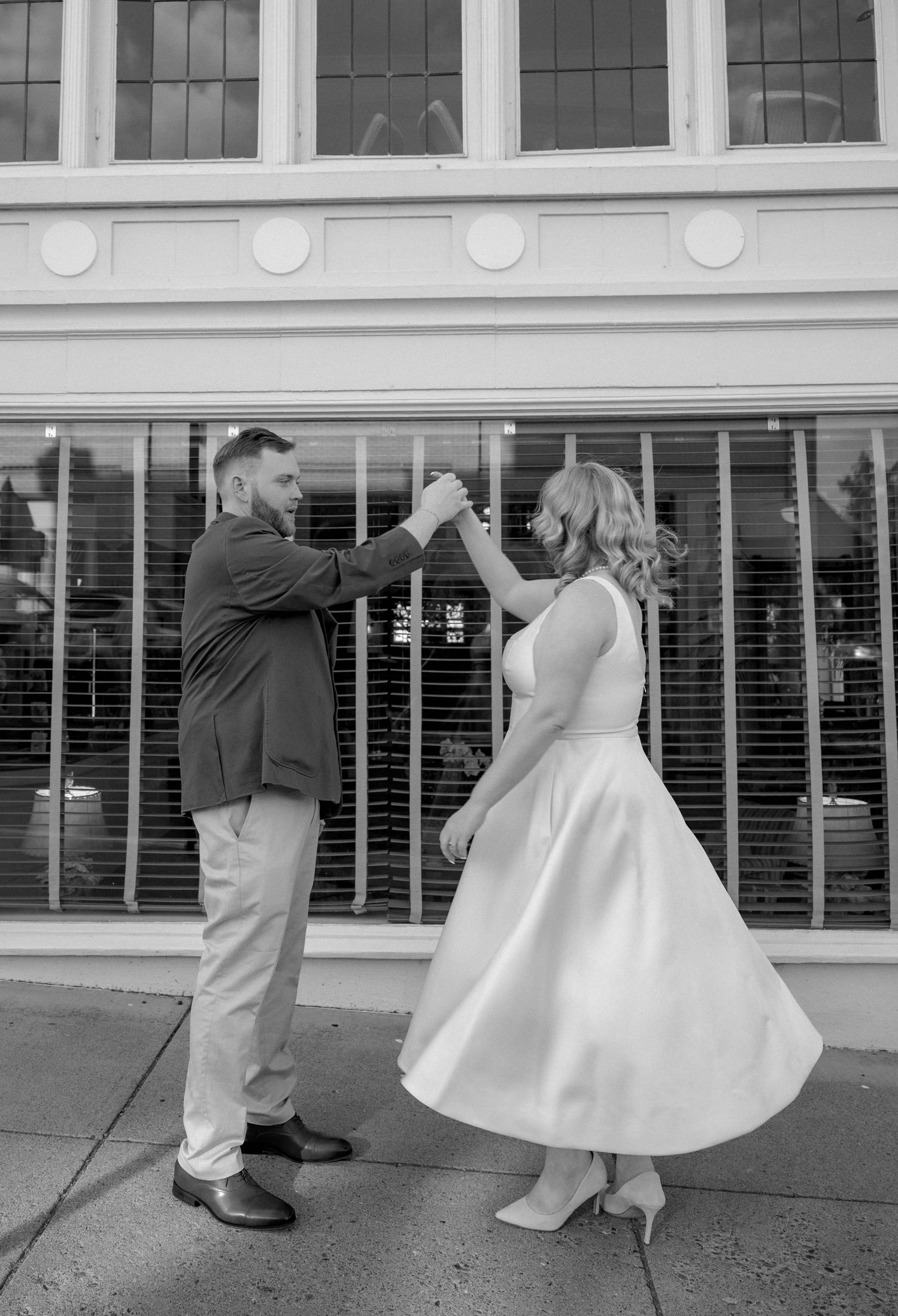 A sequence of playful poses on a sidewalk with a white dress flowing in the breeze.