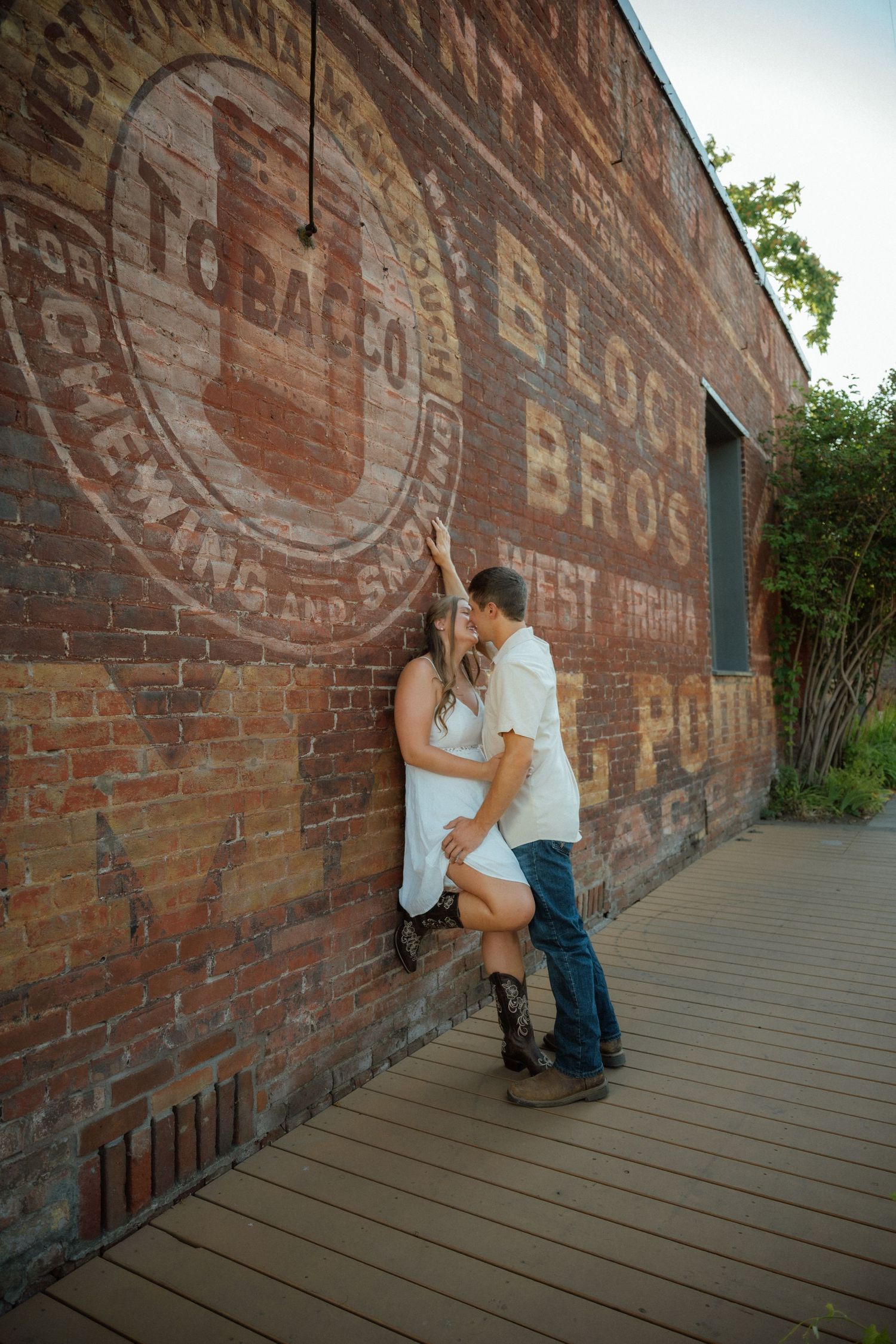 Romantic moment against vintage brick wall with old painted advertisements.