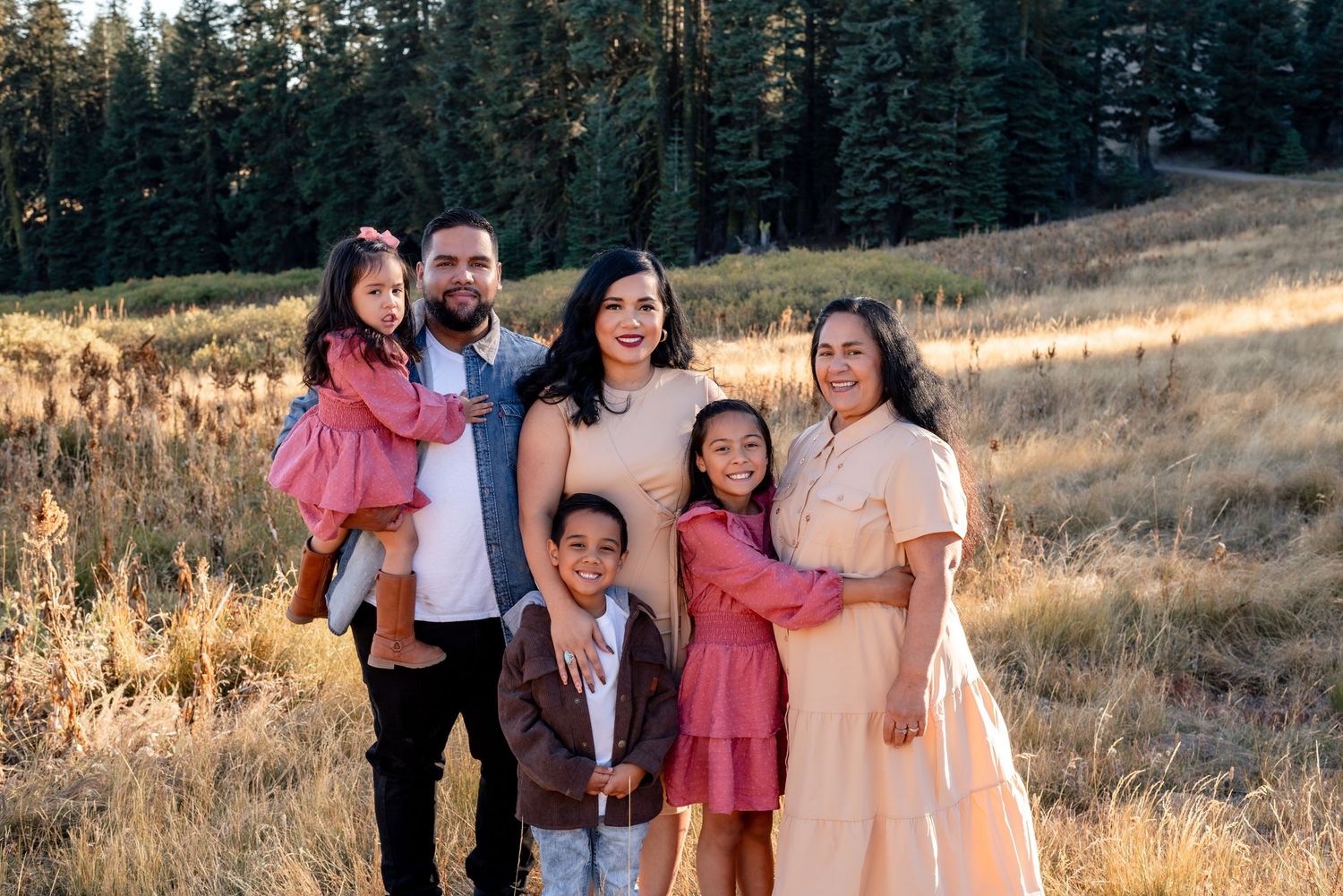 Family walking together on a scenic mountain path at sunset.