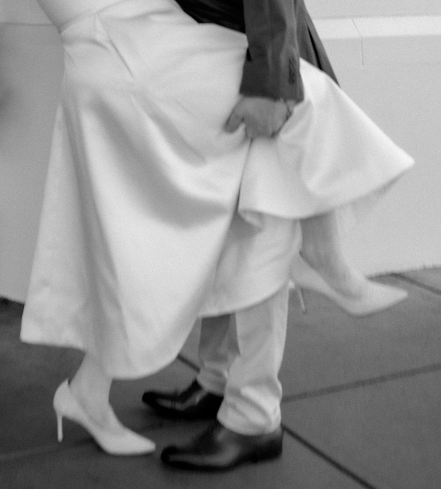 Black and white photo showing movement of flowing white fabric and legs.