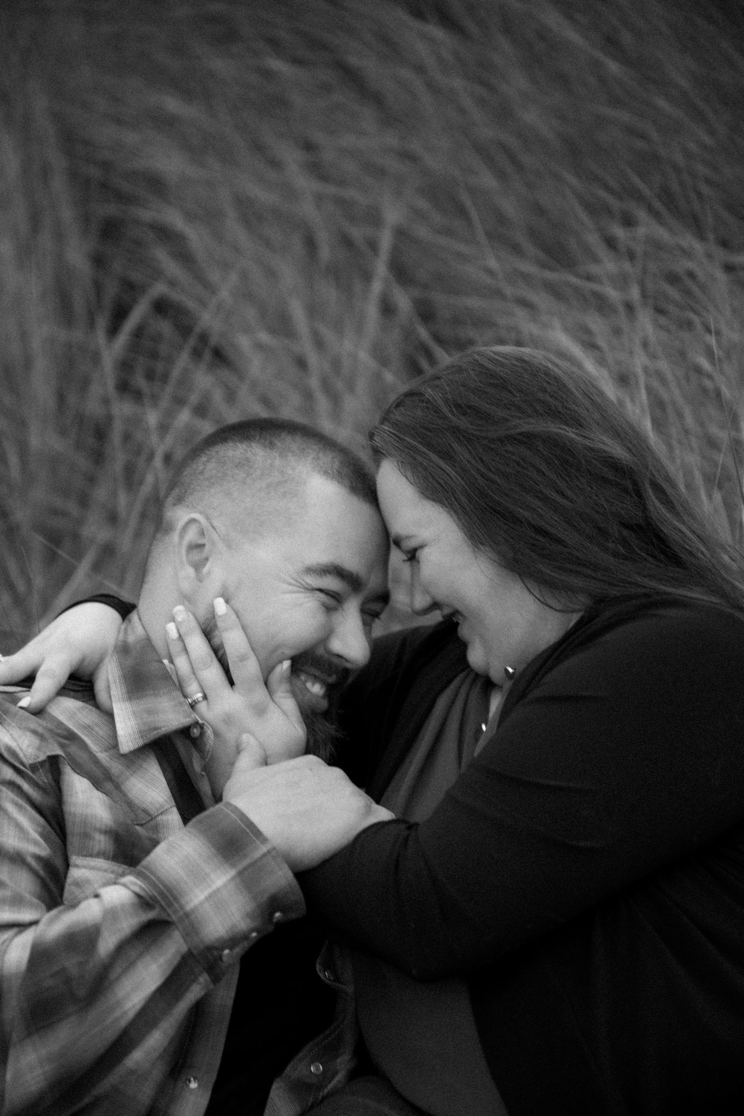 Two people share an intimate close-up moment against a dark background.
